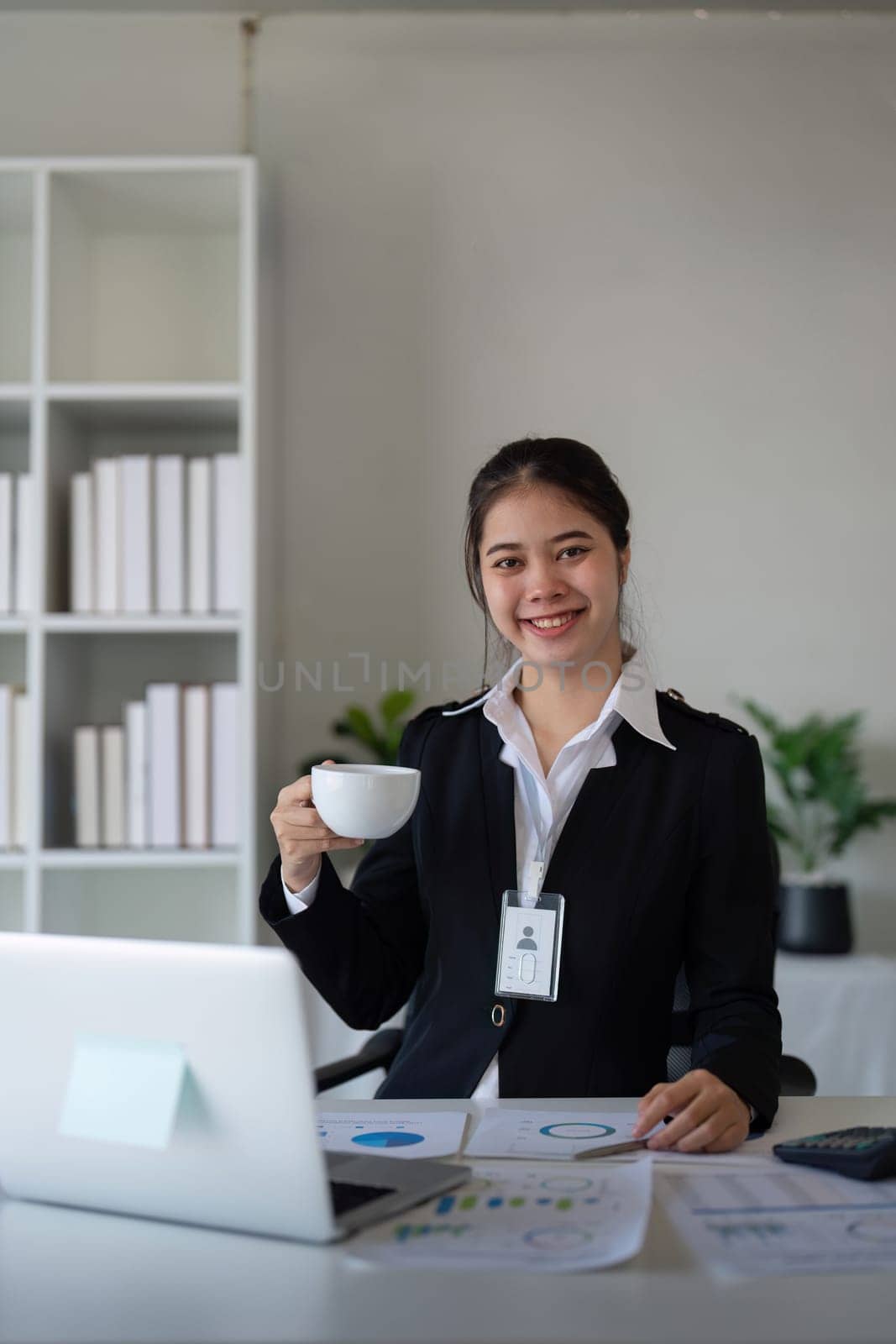 Portrait of happy and successful young Asian business woman employee in modern office.