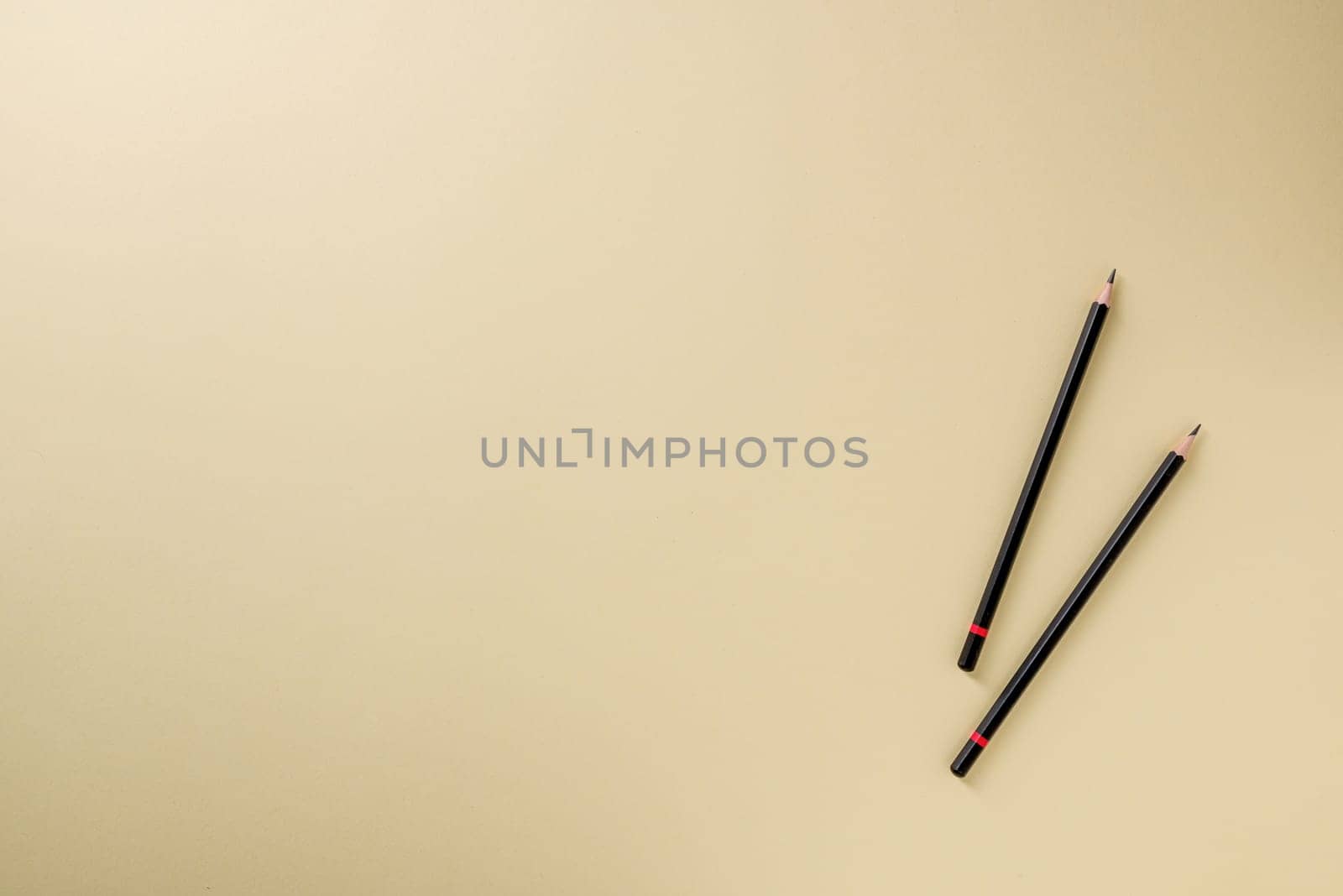 Pencil with black paint and a red stripe on a yellow background