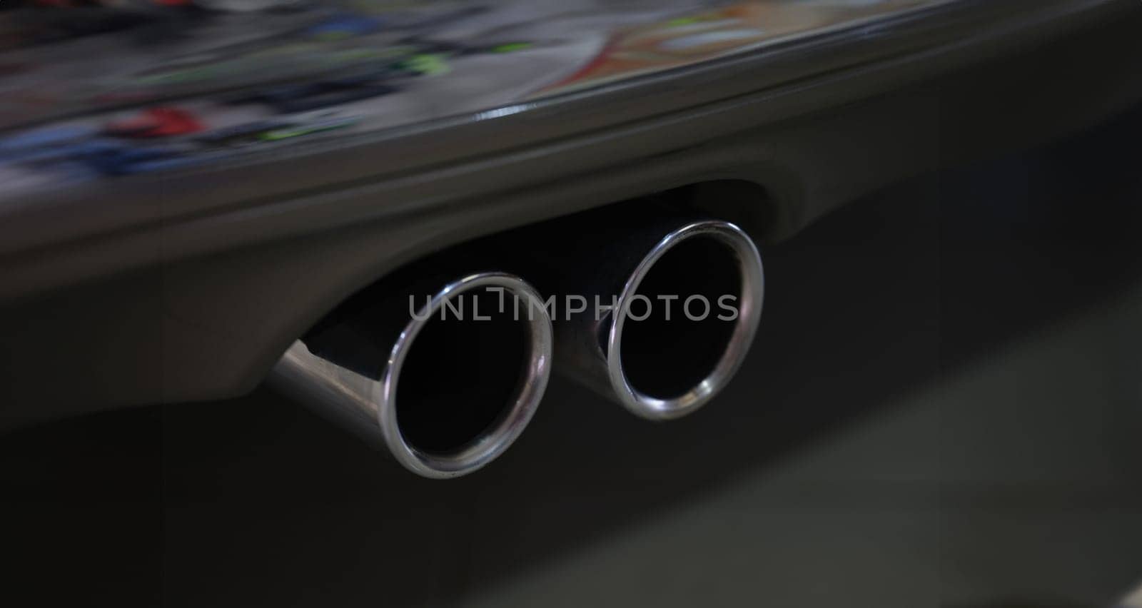 Closeup of metal exhaust pipe of sports car. Car tuning concept