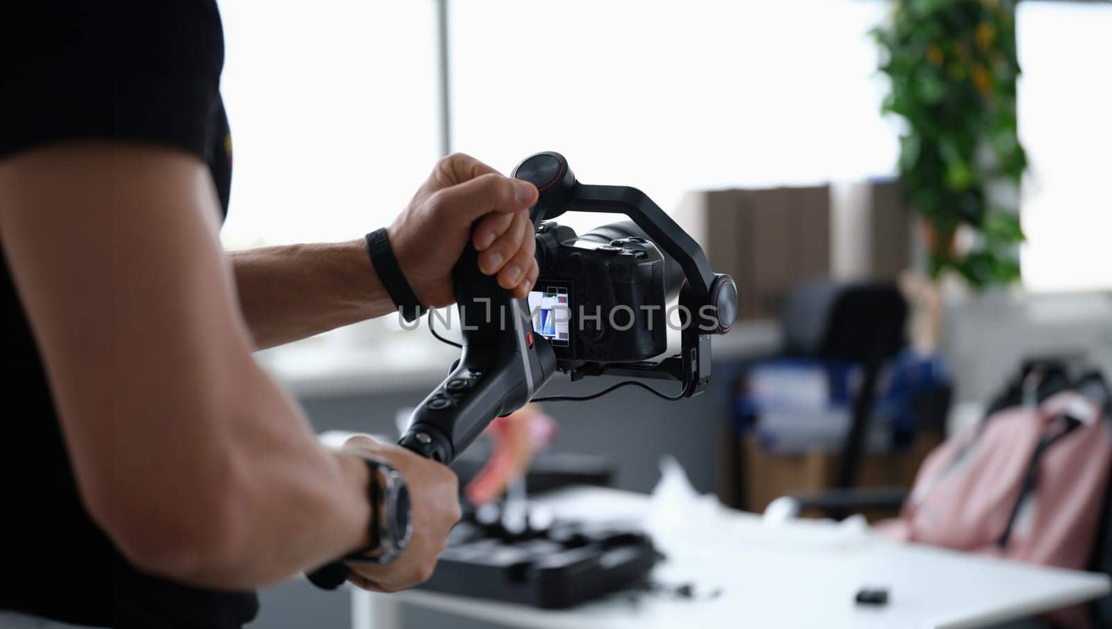 Photographer shooting video on camera from tripod closeup. Professional photographic equipment concept