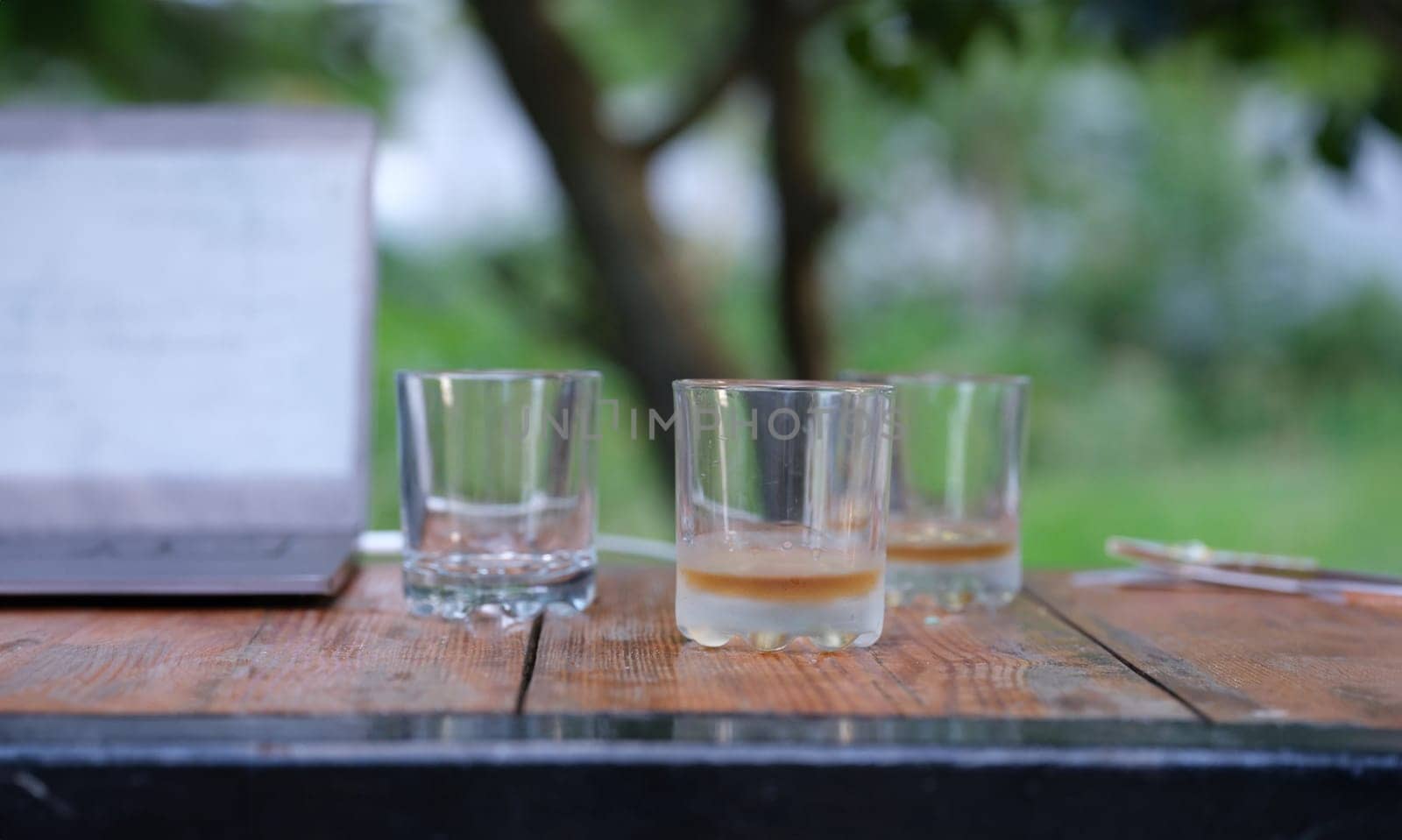 Glasses with whiskey at bottom are on table in bar closeup. Alcohol addiction concept