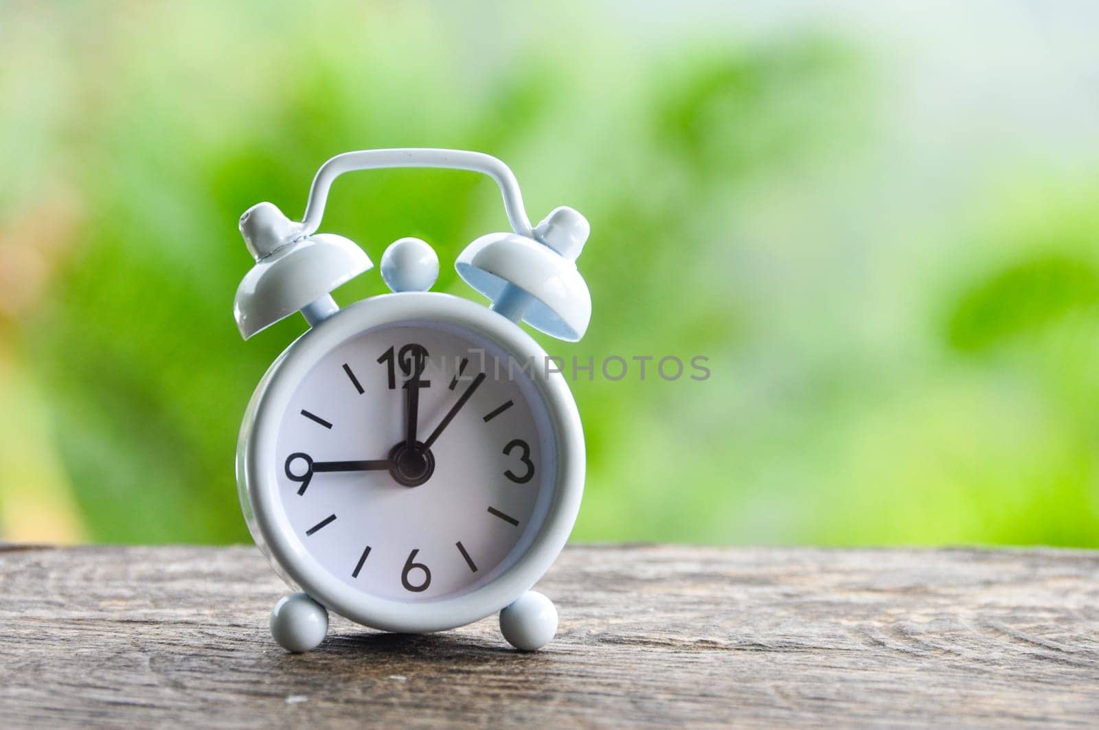 Table alarm clock pointing at 9 am. Time concept and copy space