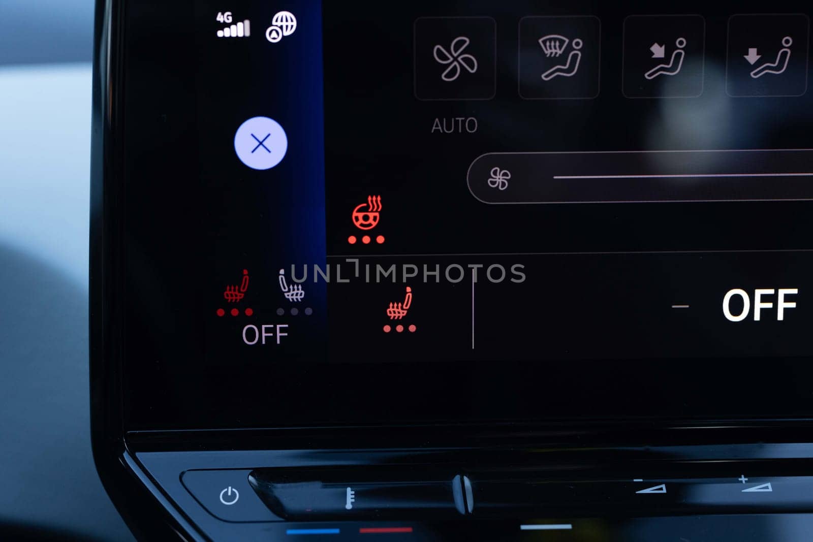 Switching ON heated seats of car by pressing the buttons. Heated seat dashboard in a car. Steering wheel heating button in the car. Electric car control panel with steering wheel and seat heating by uflypro