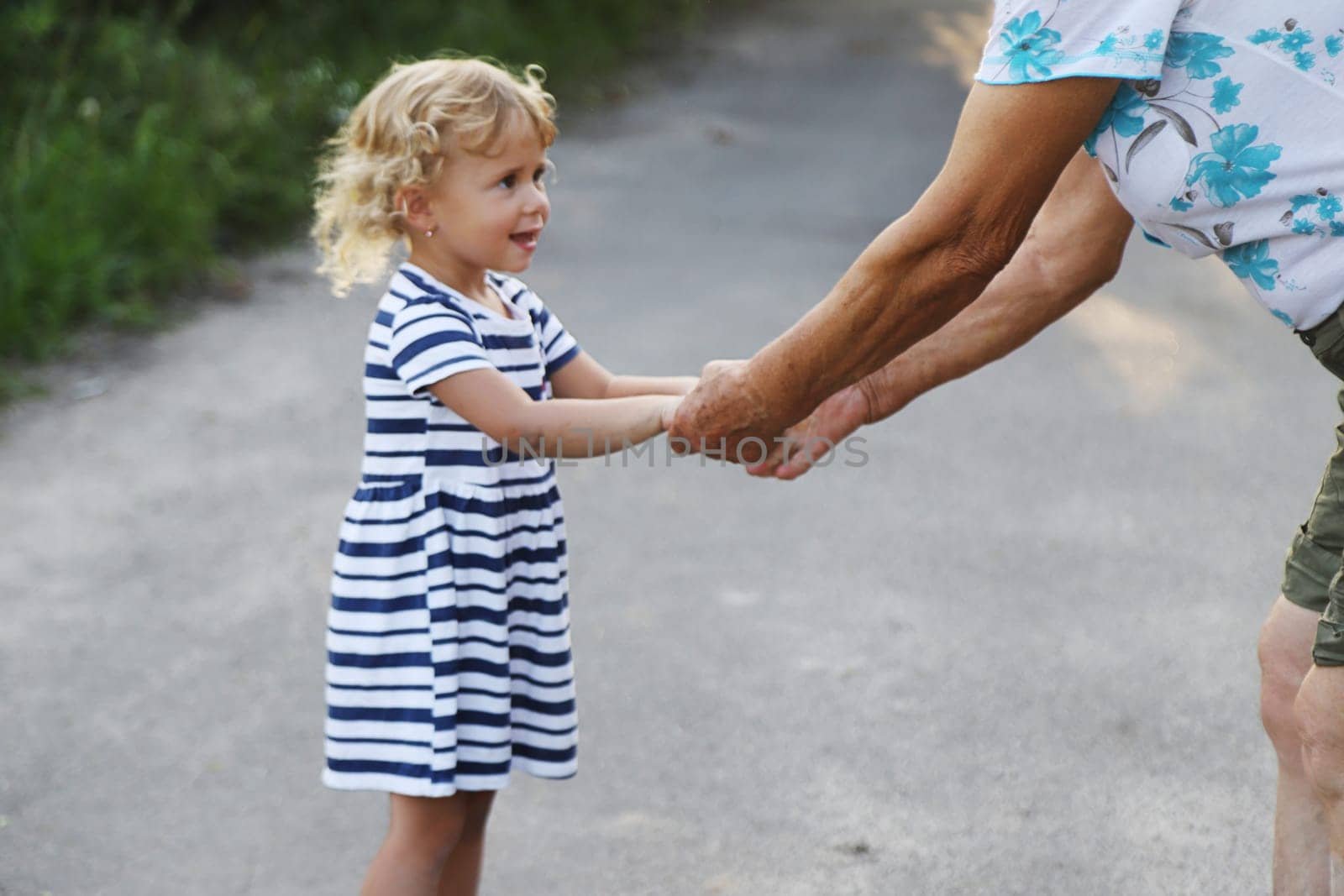 Child with grandmother holding hand. Selective focus. by yanadjana