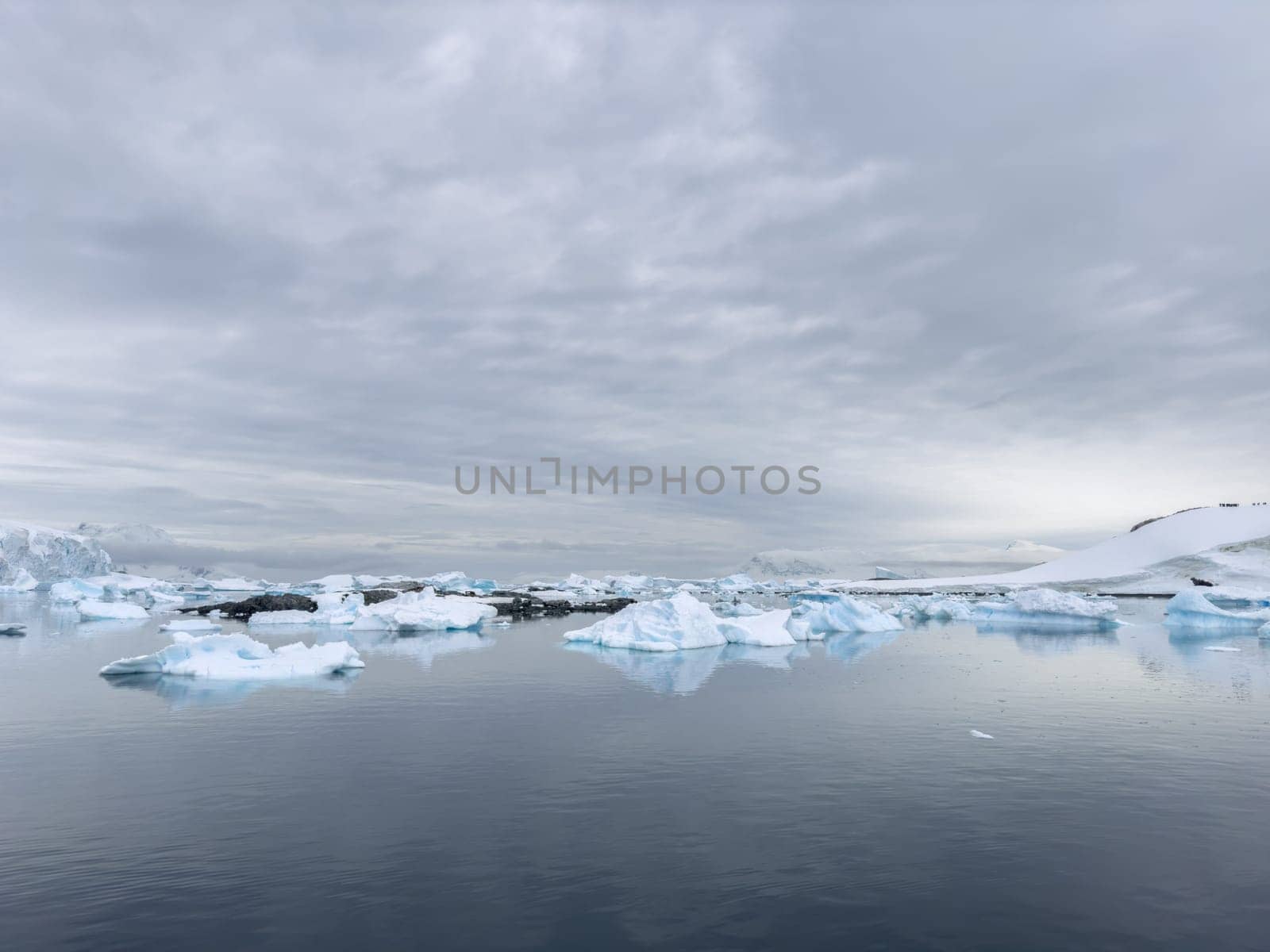 A huge high breakaway glacier in the southern ocean off the coast of Antarctica, the Antarctic Peninsula, the Southern Arctic Circle, azure water, cloudy weather by vladimirdrozdin