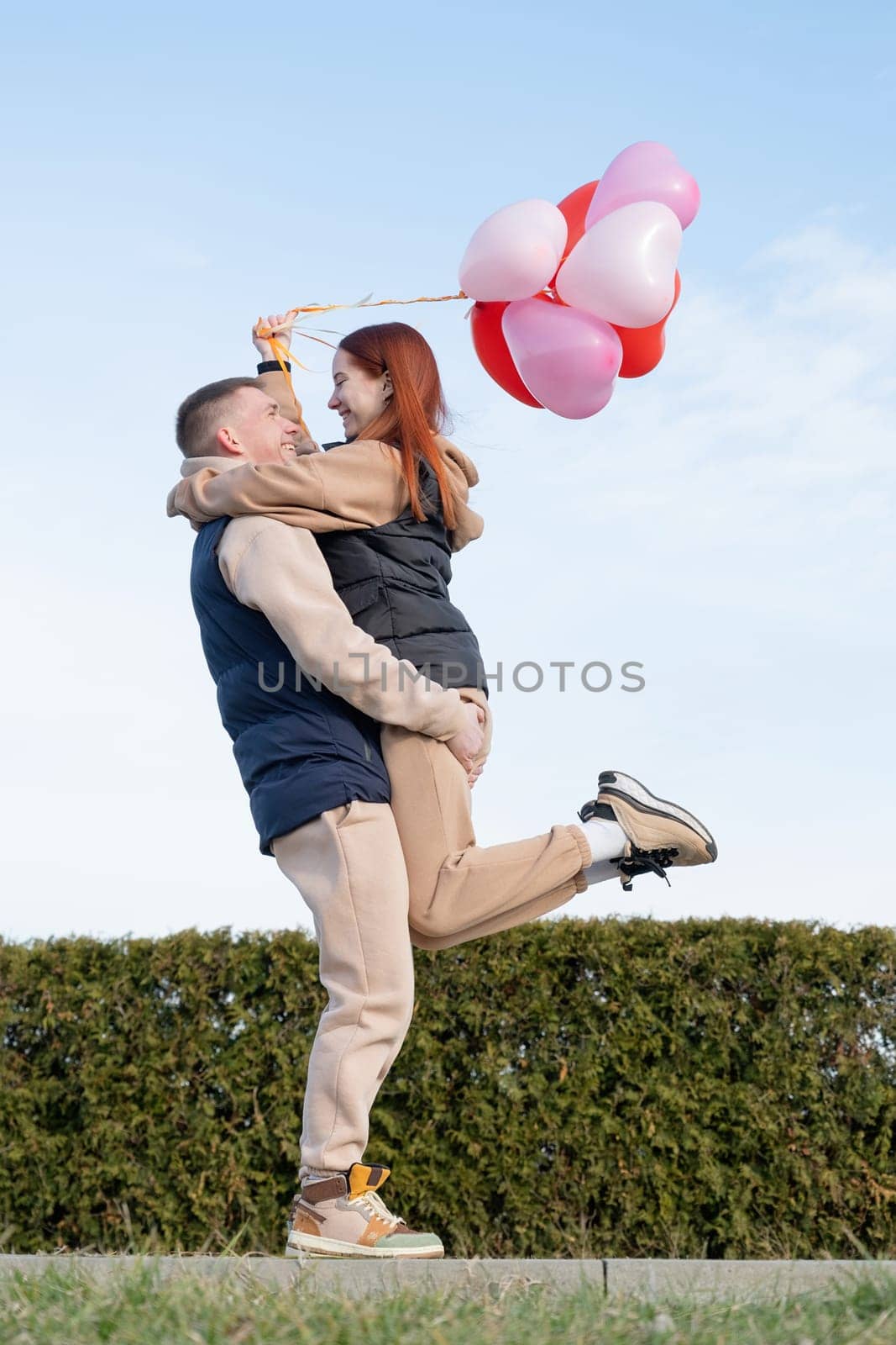 Outdoor photo of happy young woman enjoying date. cheerful romantic couple dating outdoors with balloons