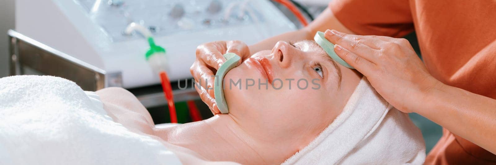 Attractive caucasian woman receive electrical facial treatment. Tranquility. by biancoblue