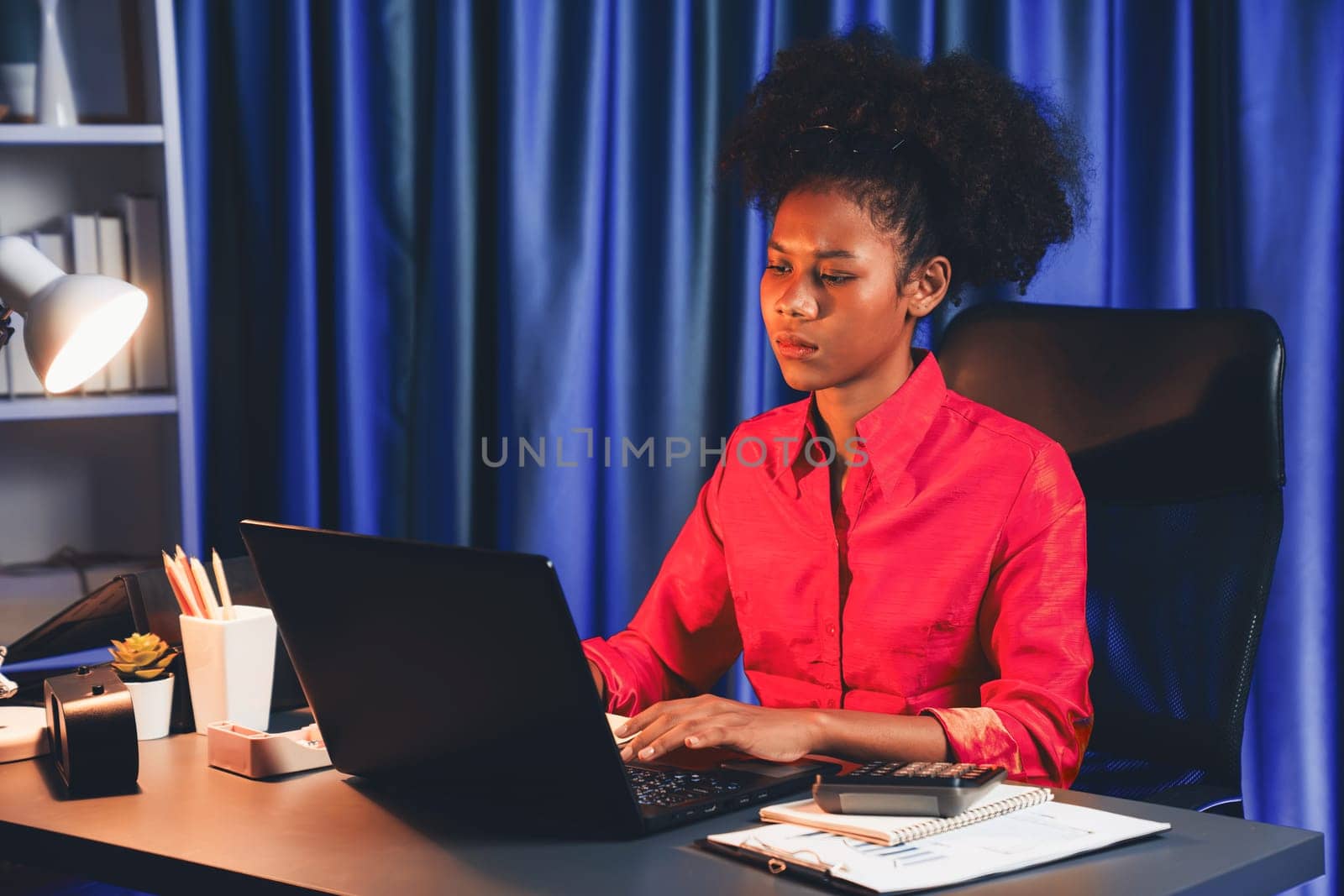 African woman businesswoman or blogger wearing pink shirt with serious face, looking and focusing on screen laptop with struggle project. Concept of stressful expression at work from home. Tastemaker.