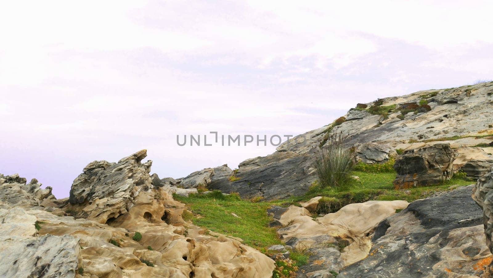 Mount with grass and limestone on the coast of the sea