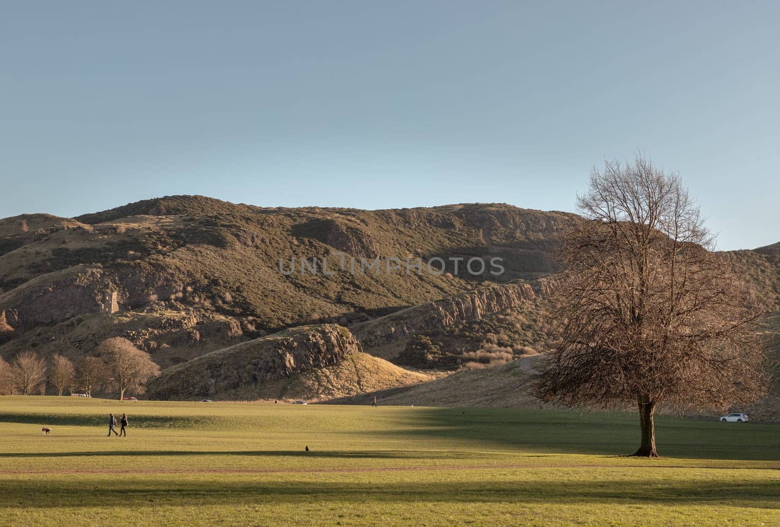 The breathtaking scenic landscape of Holyrood park with Salisbury Crags rugged hills and sky background. View of Edinburgh city. Space for text, Selective focus.