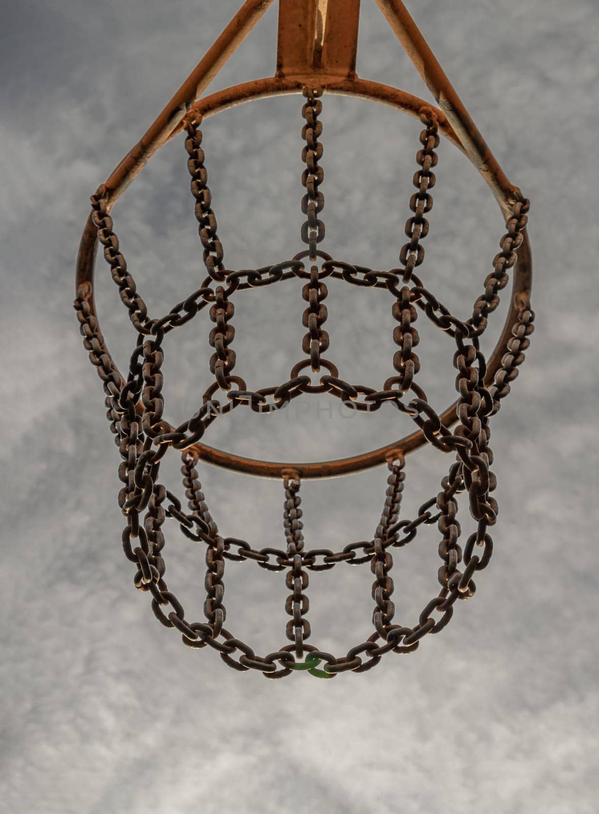 Edinburgh, Scotland, Jan 19, 2024 - View of hoop metal and steel chain net against sky background seen from below. Street basketball court, Low angle view, Look up, Space for text, Selective focus.