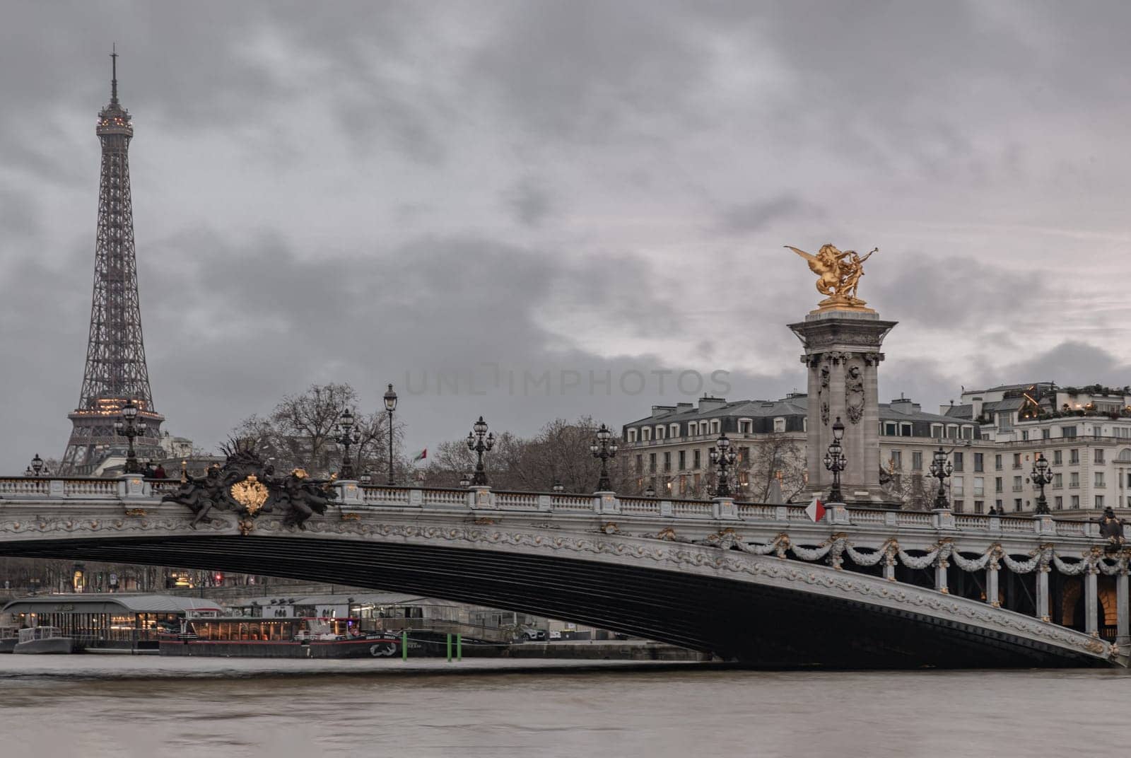 France, Paris - Jan 04, 2024 - Nice evening scenery of Eiffel Tower and Pont Alexandre III Bridge on Seine River in Paris. Destinations in Europe. Space for text, Selective focus.