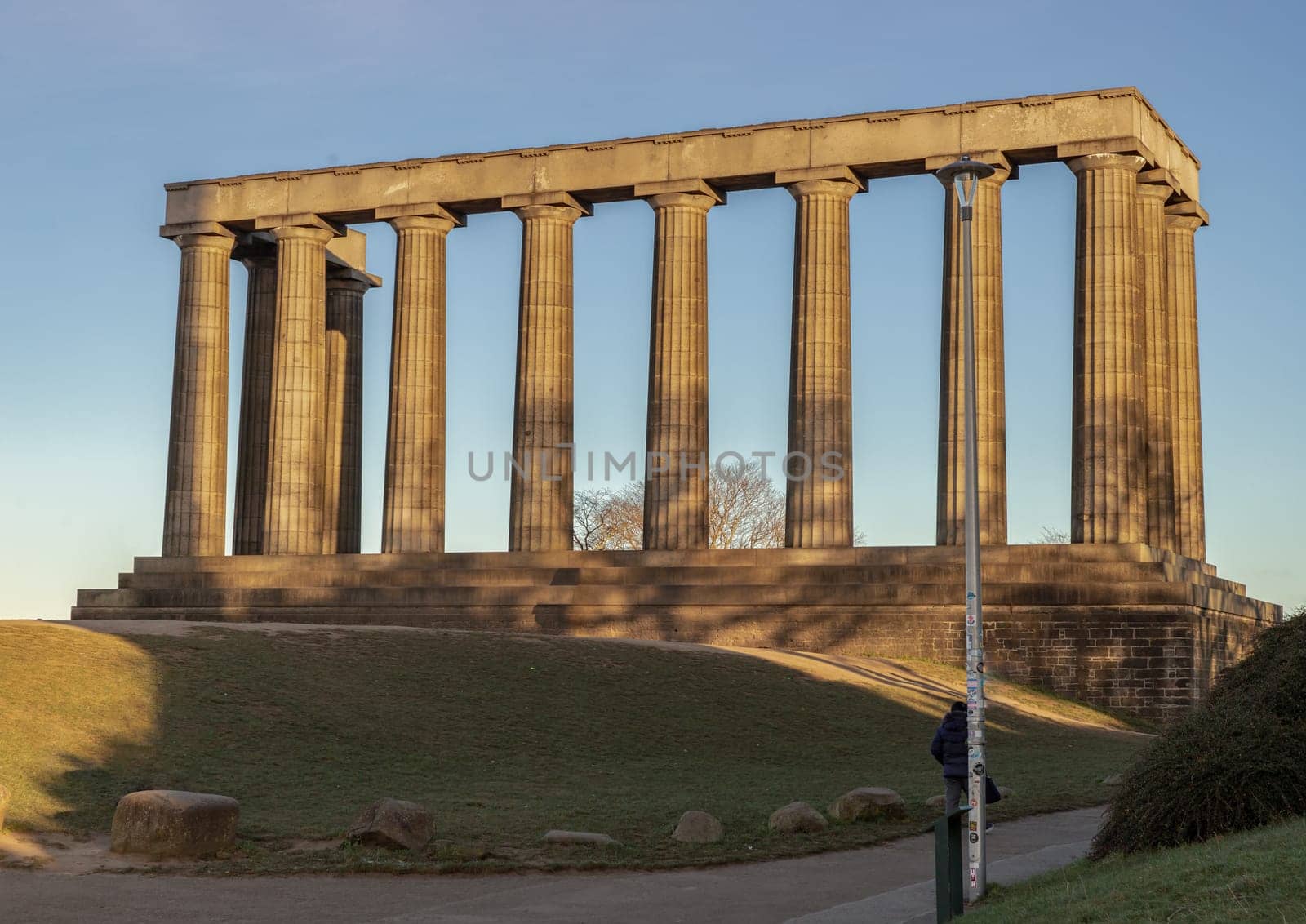 Edinburgh, Scotland - Jan 18, 2024 - A view of the National Monument of Scotland with a bright blue sky in the background situated on Calton Hill at Edinburgh city. Scotland, Space for text, Selective focus.
