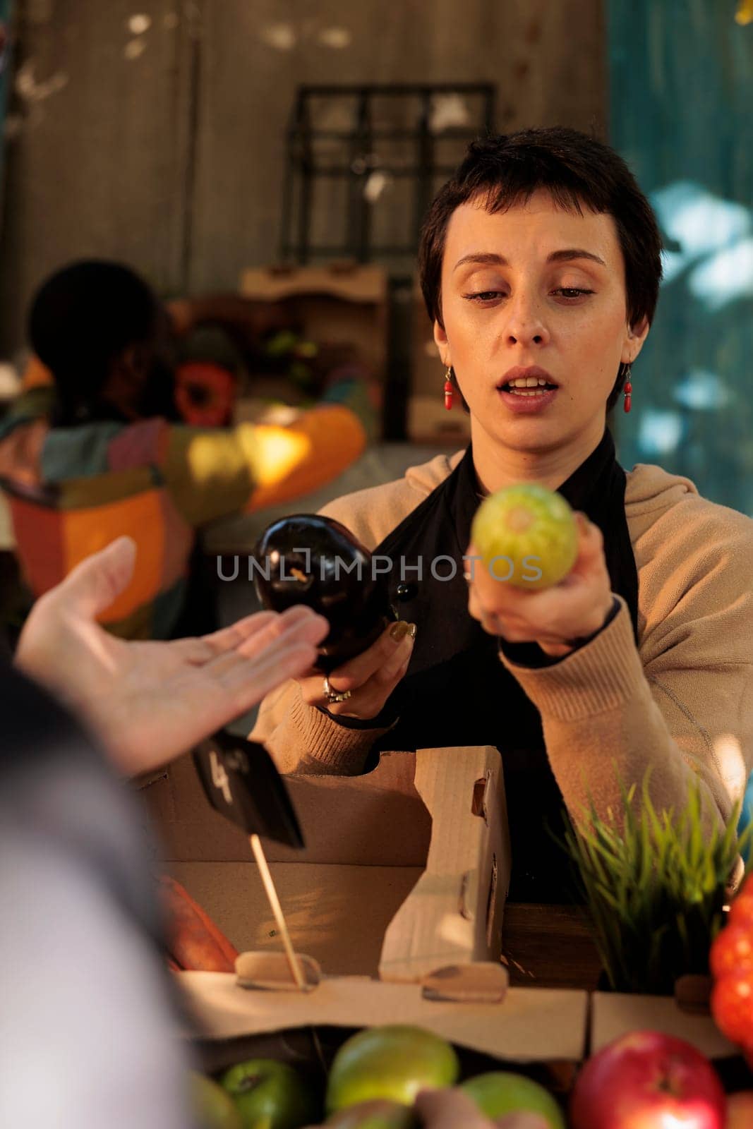 Woman selling eco organic fruits at local farmers market by DCStudio