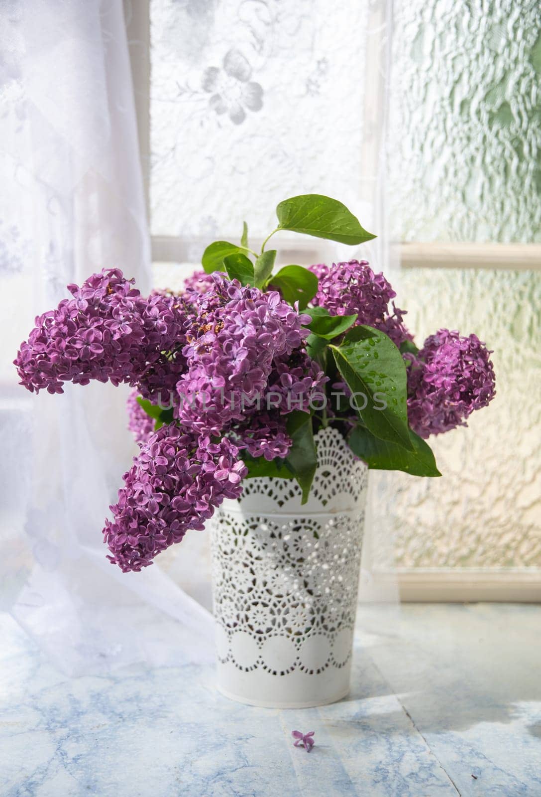 bouquet of purple lilacs in white openwork bucket on old shabby window sill with tulle curtain, romantic mood and spring freshness,comfort in the home,decoration of everyday life, High quality photo