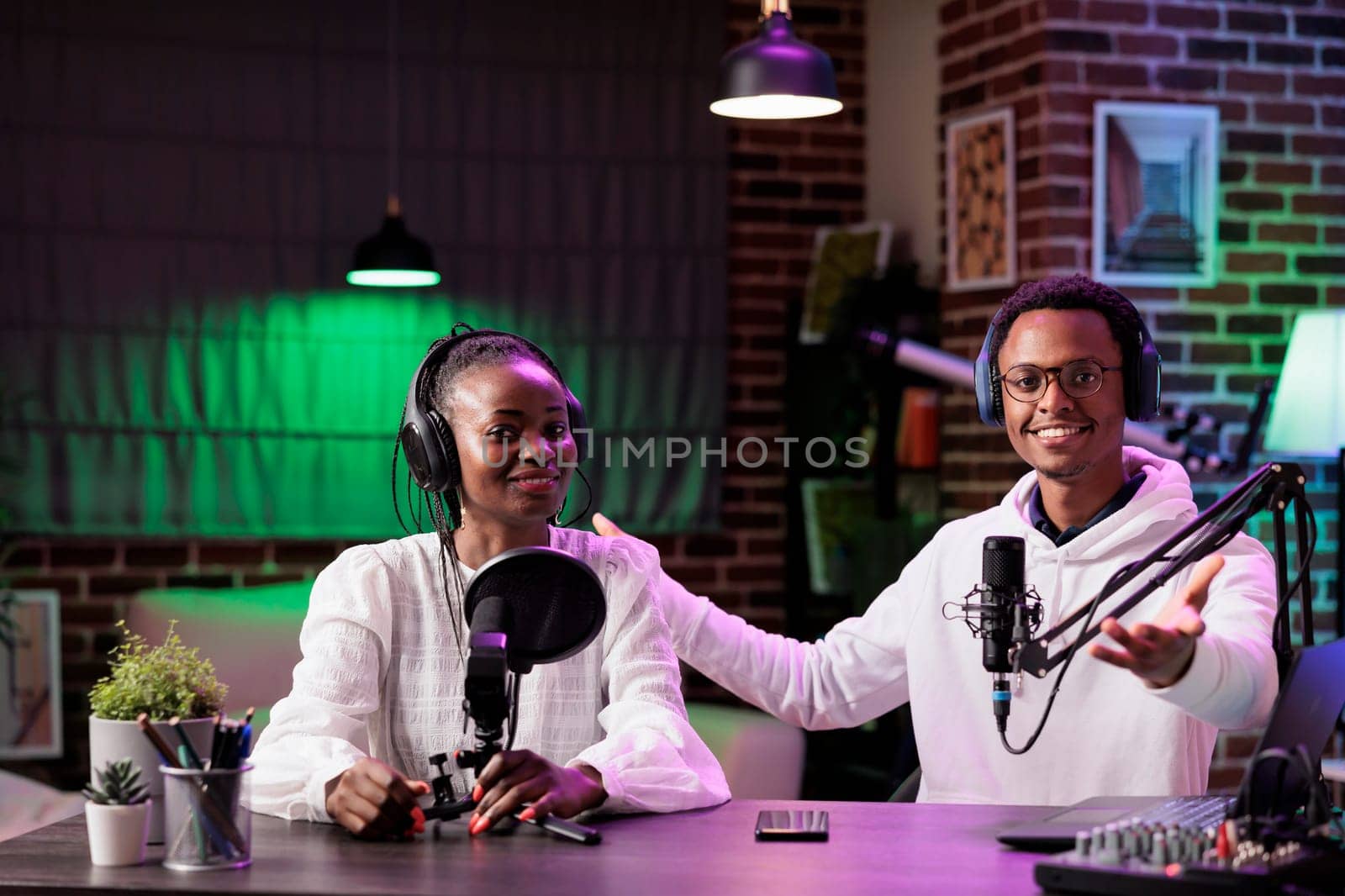 Team of content creators hosting online show in home studio, filming vlog, producing social media content. Vloggers recording episode for streaming service channel, entertaining audiences