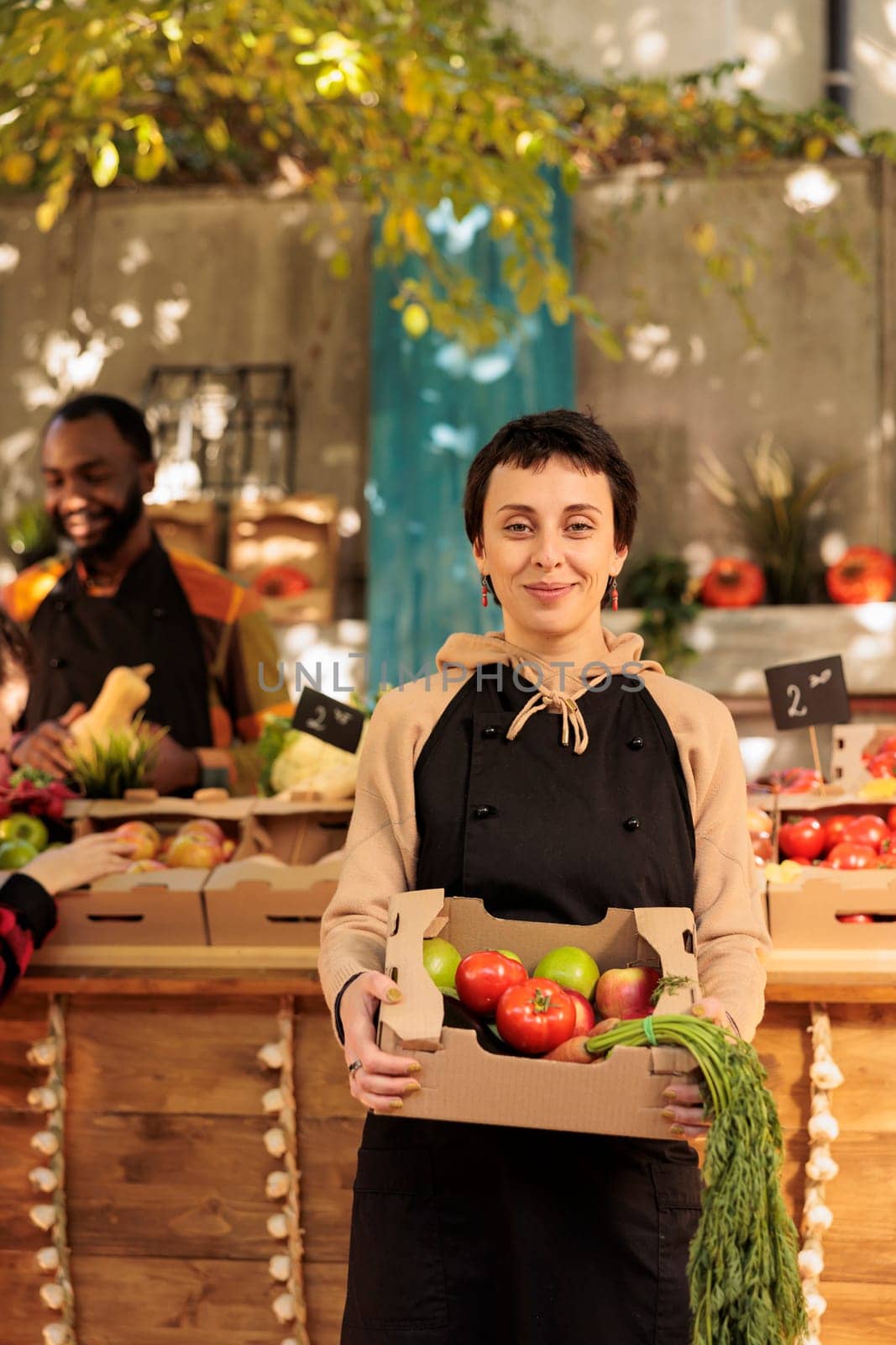Happy female farmer with fresh organic produce box by DCStudio