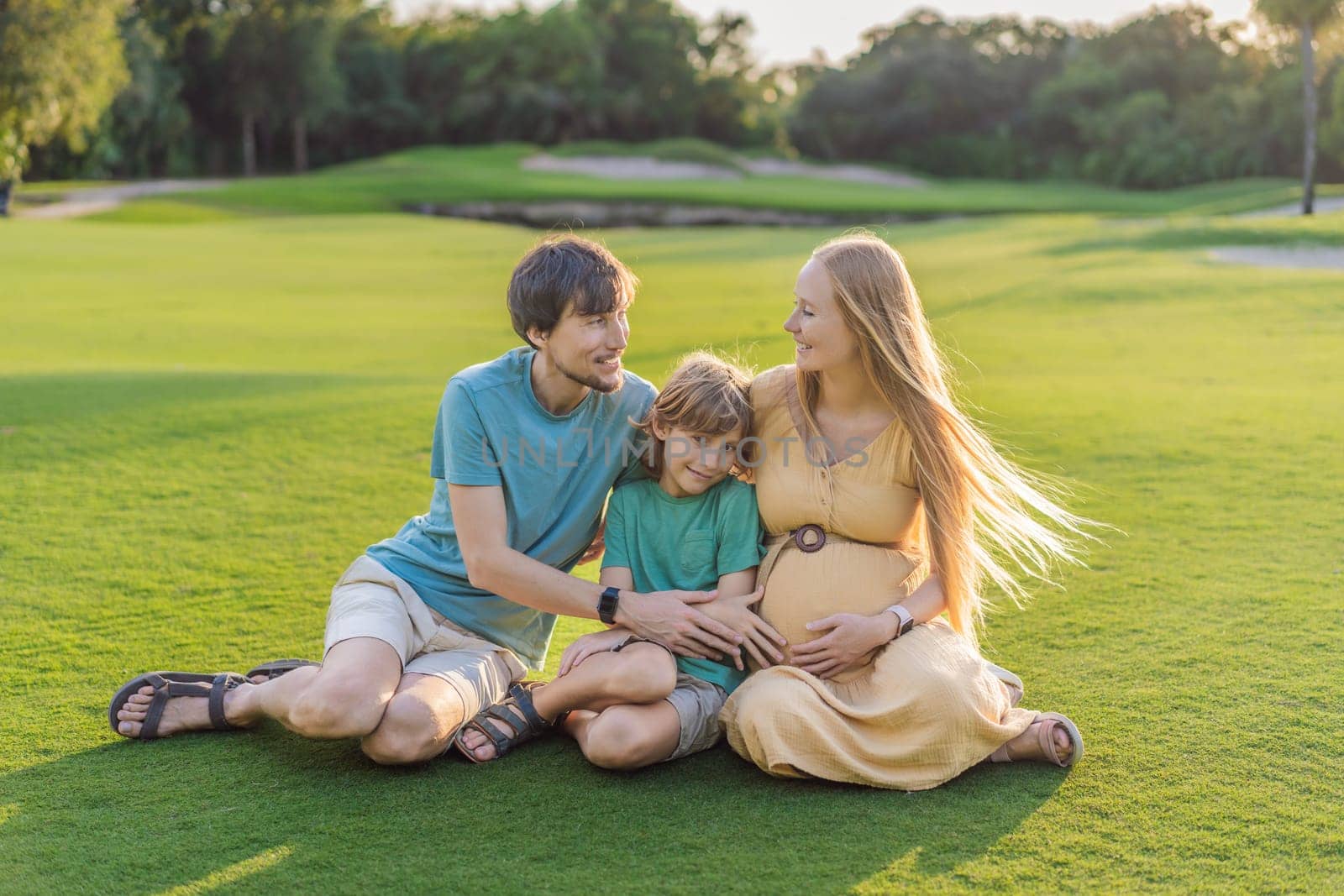 Joyful family time as a pregnant woman, her husband, and son share quality moments outdoors, embracing the beauty of nature and creating cherished memories together by galitskaya