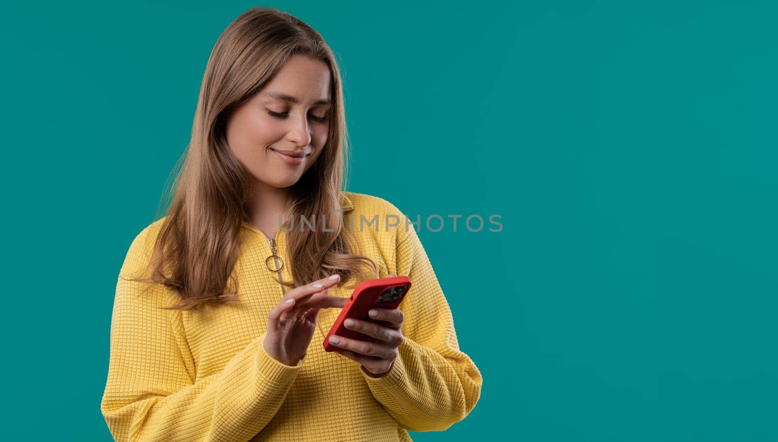 Pretty smiling woman texting in messenger on smartphone. Online dating on blue by kristina_kokhanova