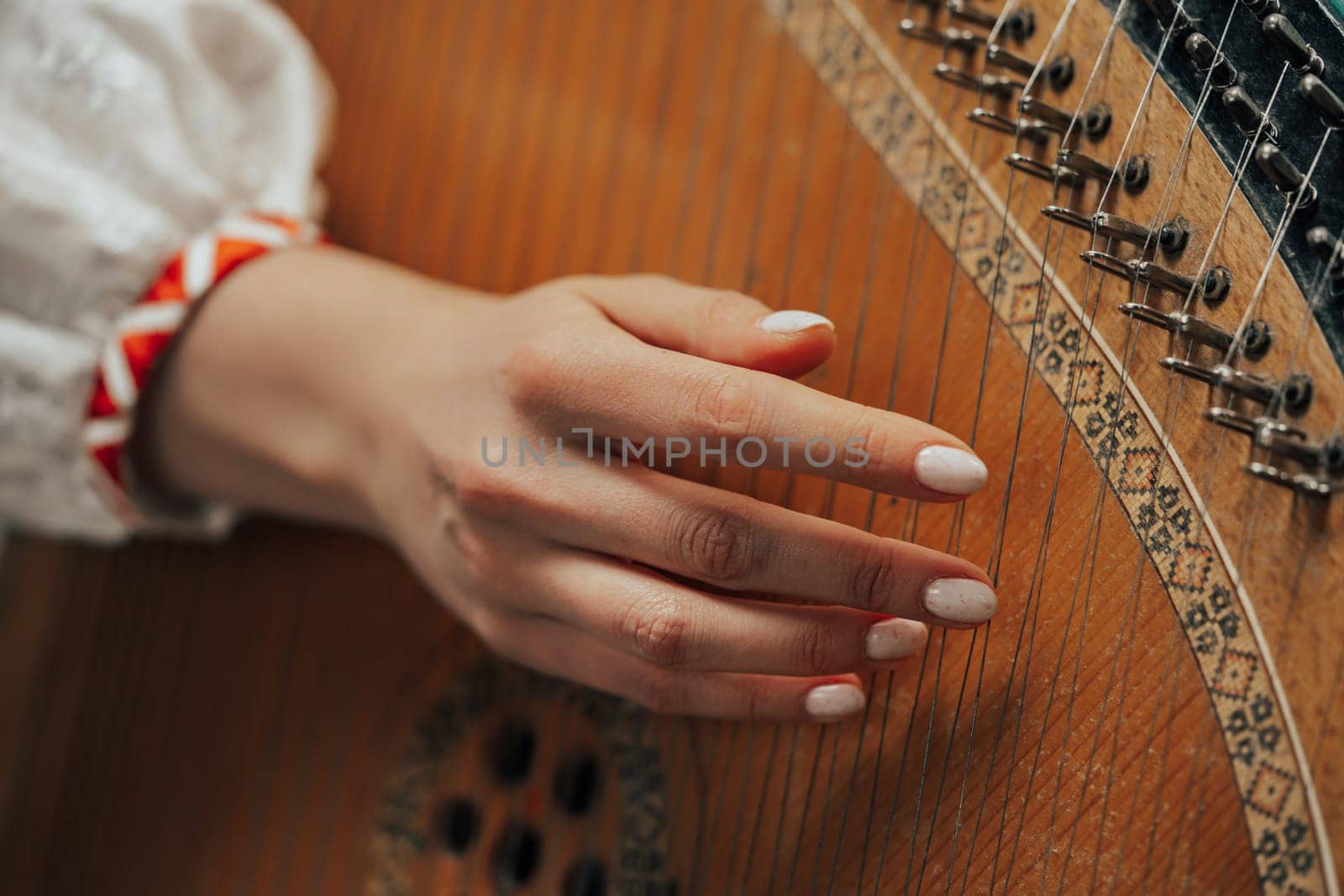 Woman playing on ethnic traditional ukrainian instrument bandura or pandora by kristina_kokhanova
