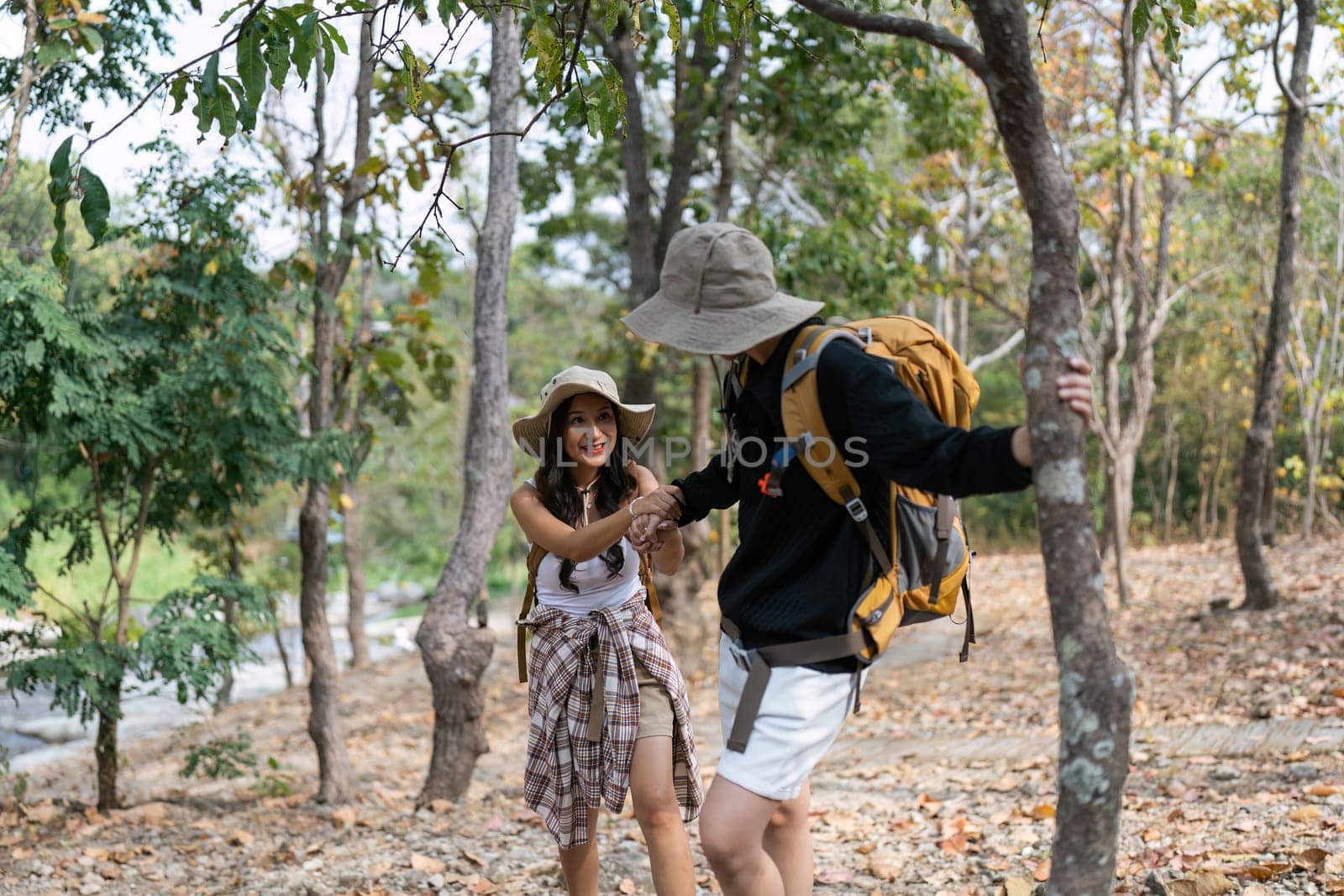 Happy LGBT Lesbian couple Travelers Hiking with Backpacks in forest Trail. LGBT Lesbian Couple Hikers with backpacks walks in mountains in vacation.