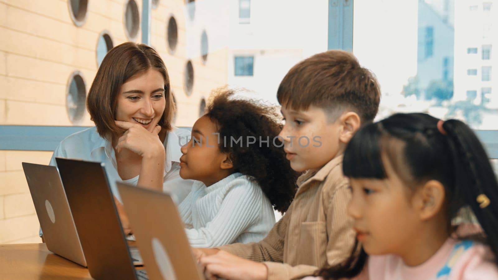 Smart teacher teaching and looking student using laptop at classroom. Professional instructor explained about programing engineering code or prompt while studying and learning program. Erudition.