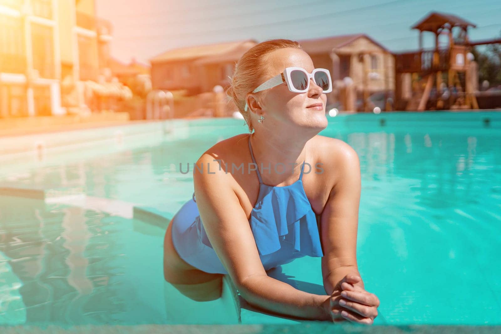 Bikini-clad woman enjoys poolside relaxation. Poolside ambiance. Capturing woman's relaxed time near pool