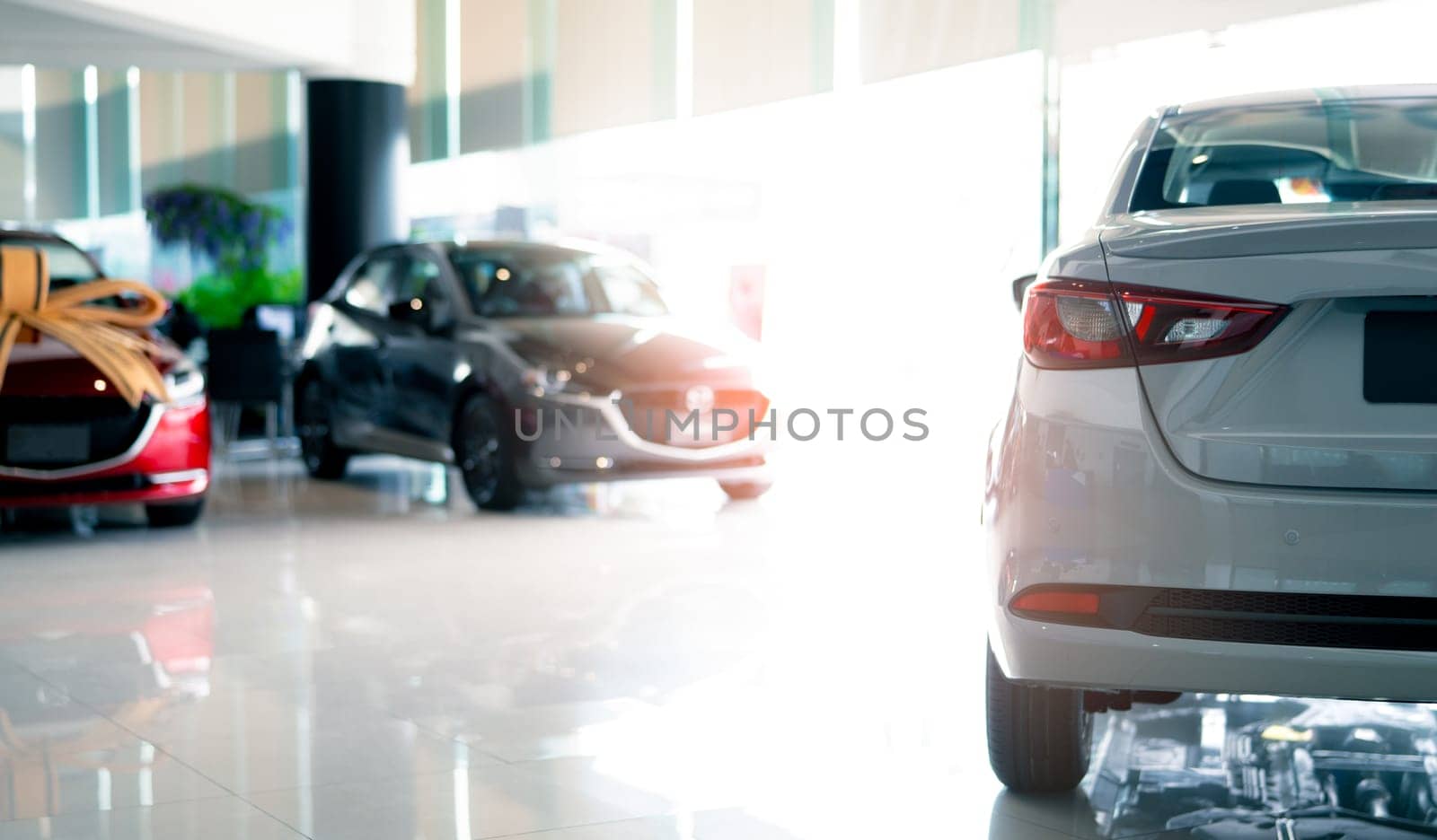 Rearview car parked in luxury showroom. Car dealership office. New car parked in modern showroom. Car for sale and rent business concept. Automobile leasing and insurance concept. Electric automobile. by Fahroni