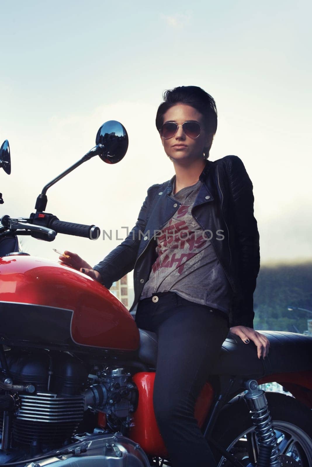 Motorcycle, leather and rebel woman in city with sunglasses for travel, transport or road trip. Fashion, evening and person with attitude on classic or vintage bike for transportation or journey.
