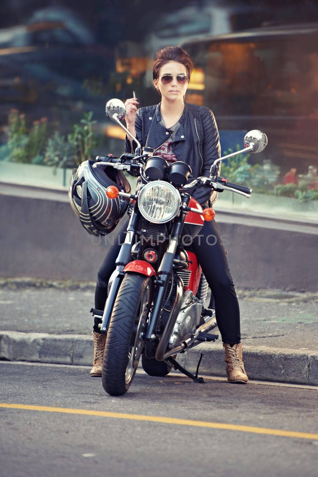 Motorcycle, leather and woman in city with cigarette for travel, transport or road trip as rebel. Fashion, street and smoke with model on classic or vintage bike for transportation or journey.