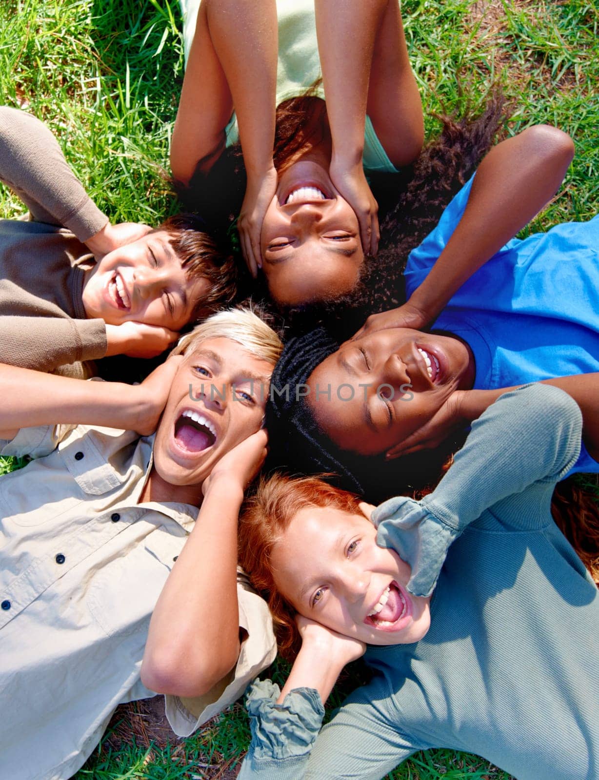 Children, friends and cover ears in outdoors for silence, quiet and ignoring noise in nature. Diversity, kids and laughing for humor or funny joke on grass, top view and bonding in childhood for fun by YuriArcurs