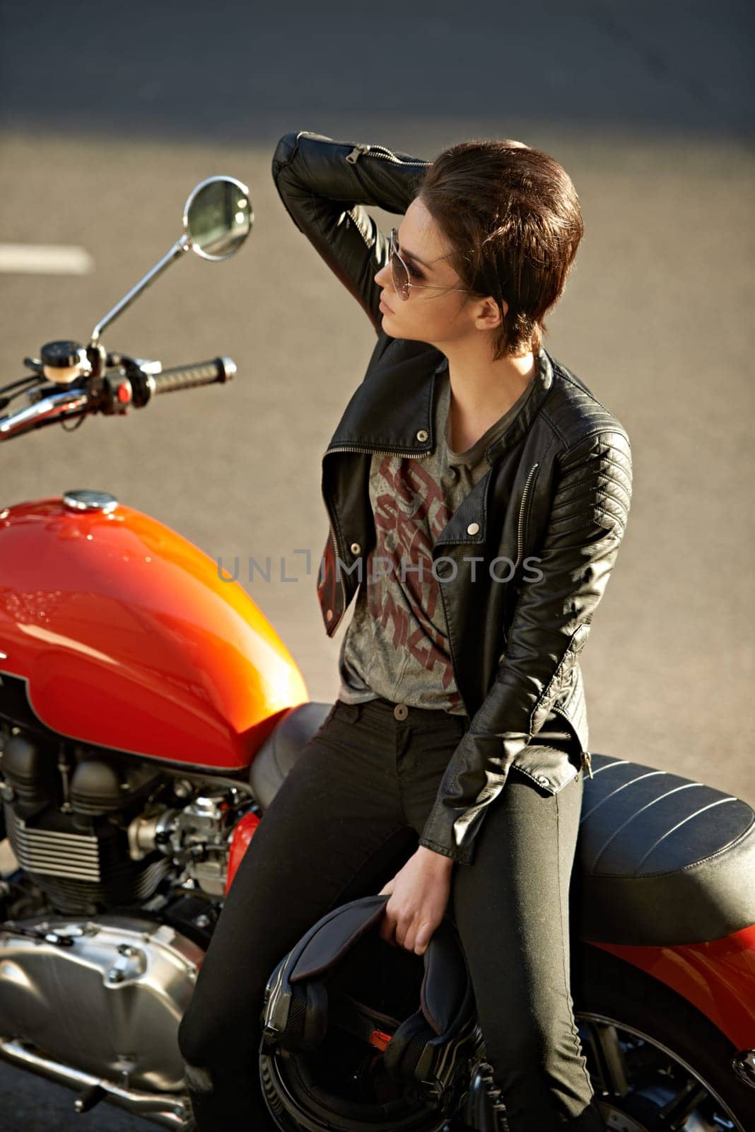 Motorcycle, street and woman in city with sunglasses for travel, transport or road trip as rebel. Fashion, leather and model with attitude on classic or vintage bike for transportation or journey.