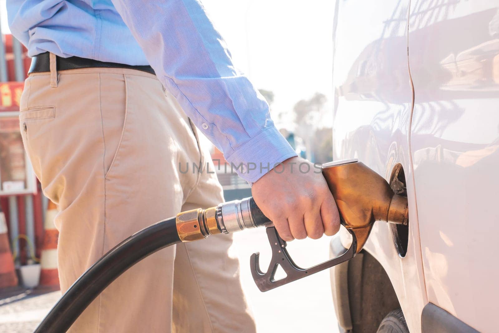 Close up man pumping gas. Car refueling on petrol station by PaulCarr