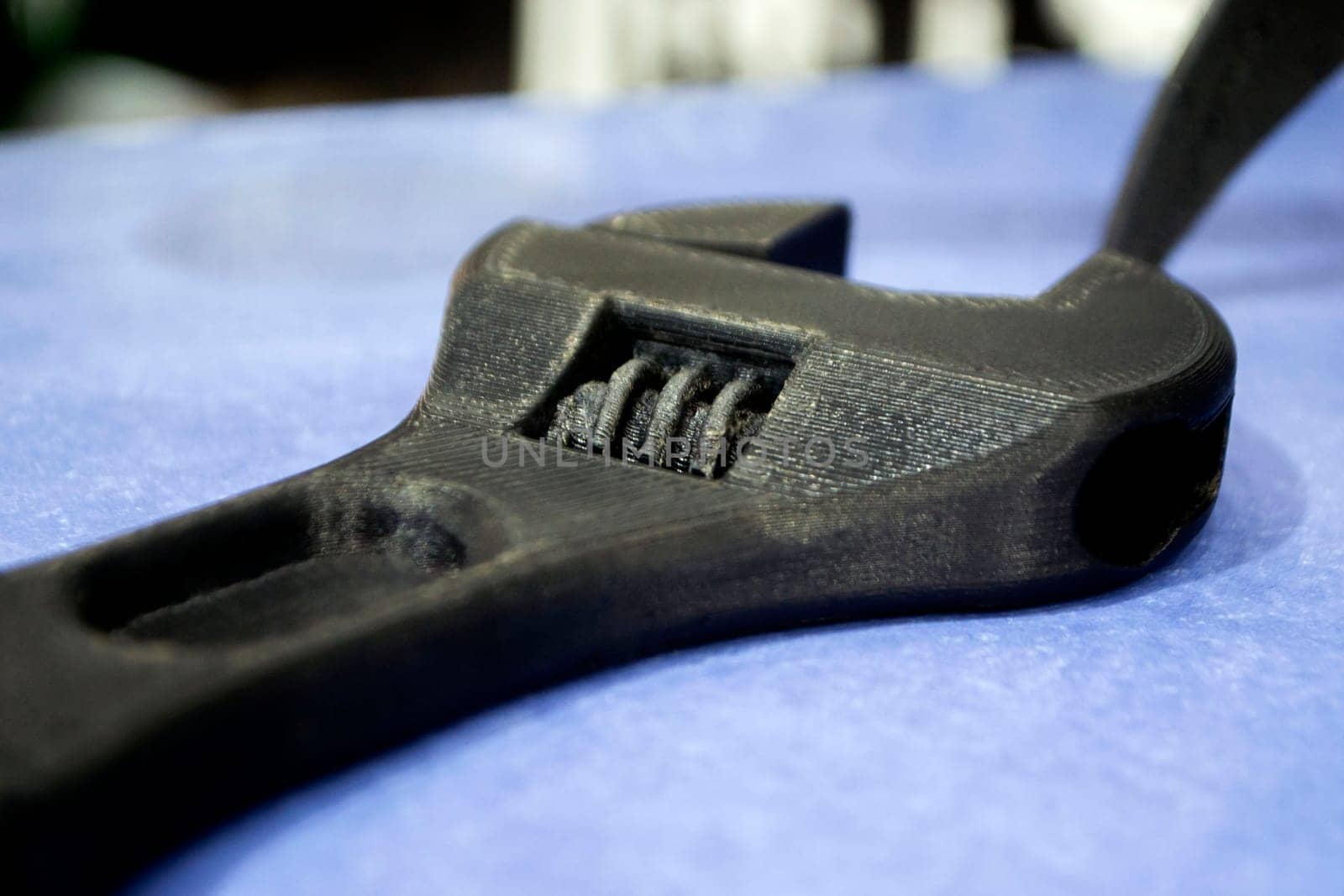Model prototype of an adjustable wrench from of black plastic printed on a 3D printer. Concept 3D printer, 3D printing, modeling prototyping three dimensional object. Innovative additive production