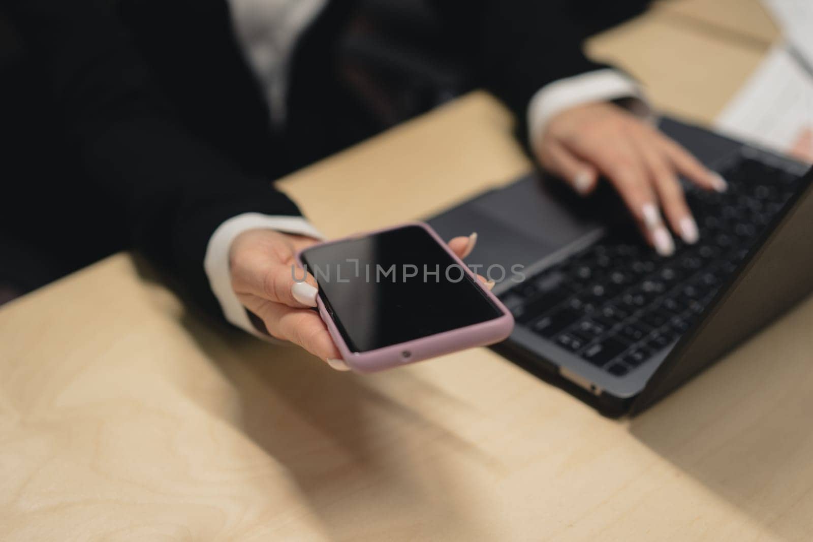 Small business entrepreneur looking at her mobile phone and smiling.