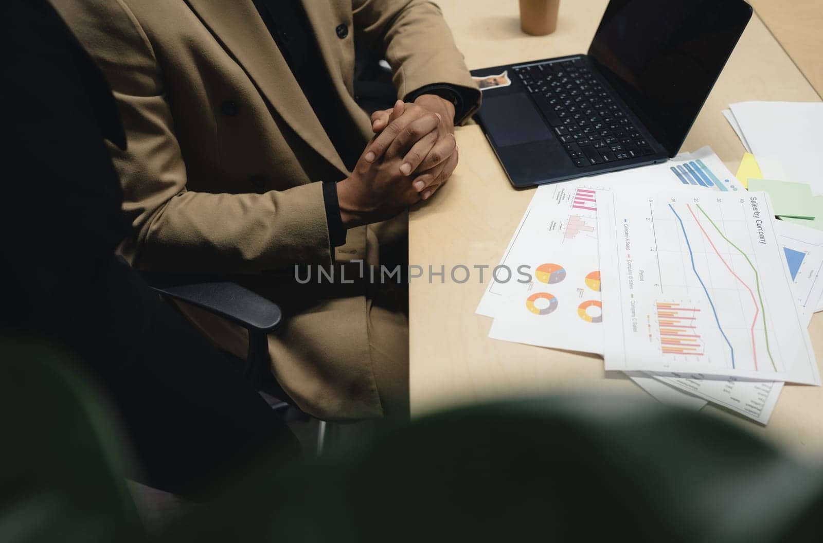 Man sitting by table working on laptop computer.