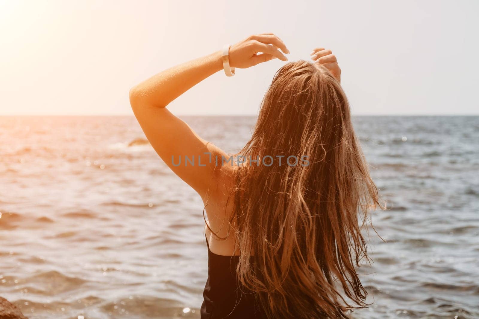 Woman summer travel sea. Happy tourist in hat enjoy taking picture outdoors for memories. Woman traveler posing on the beach at sea surrounded by volcanic mountains, sharing travel adventure journey by panophotograph