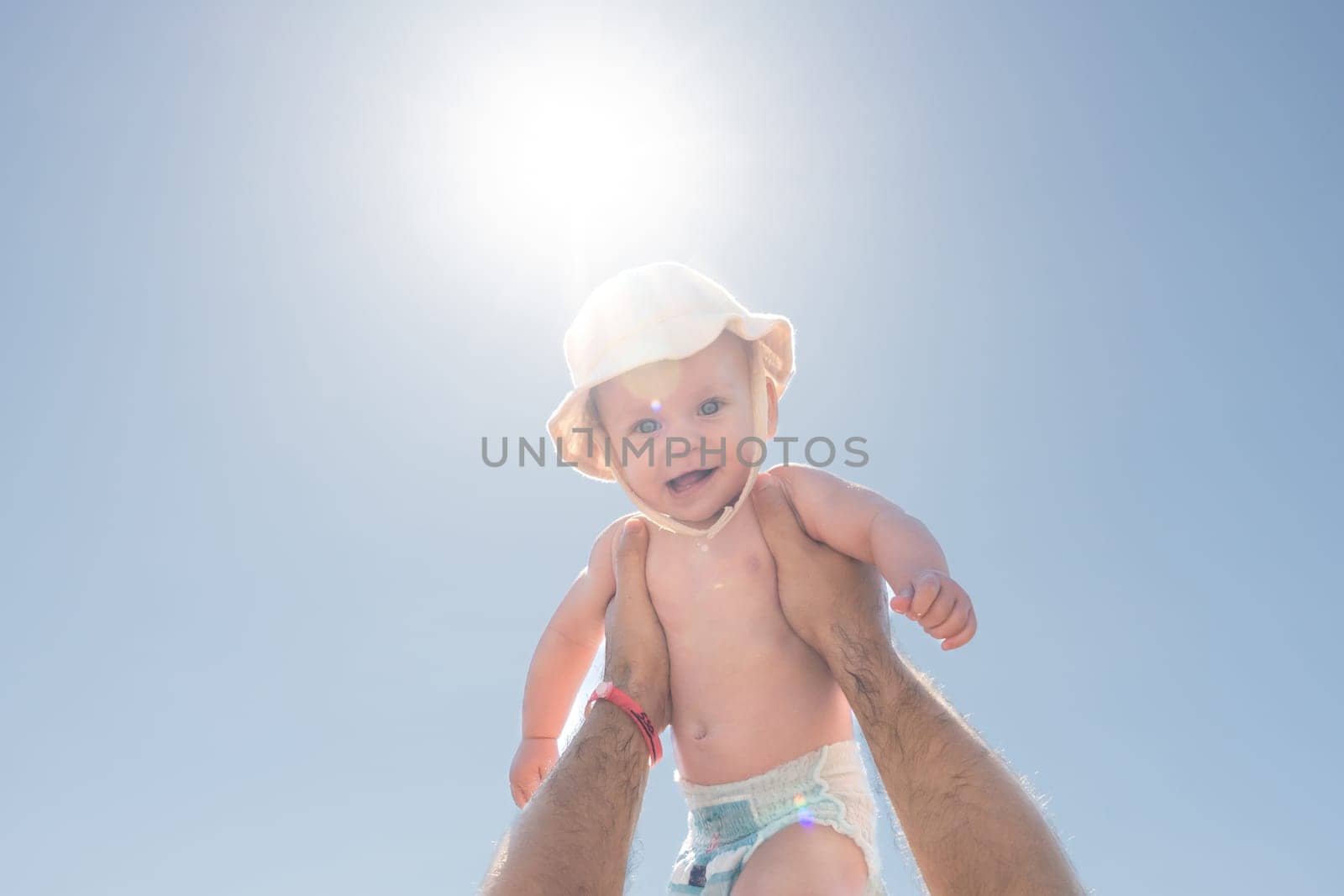 Father and child in a playful sky-high embrace under the sun. Concept of happiness and fatherly affection by Mariakray