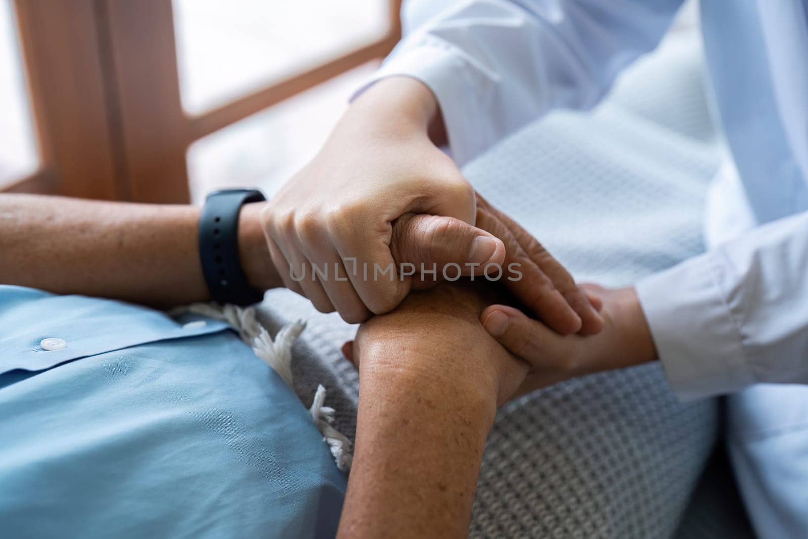 Doctors or nurses hold hands of elderly patients to support and soothe.