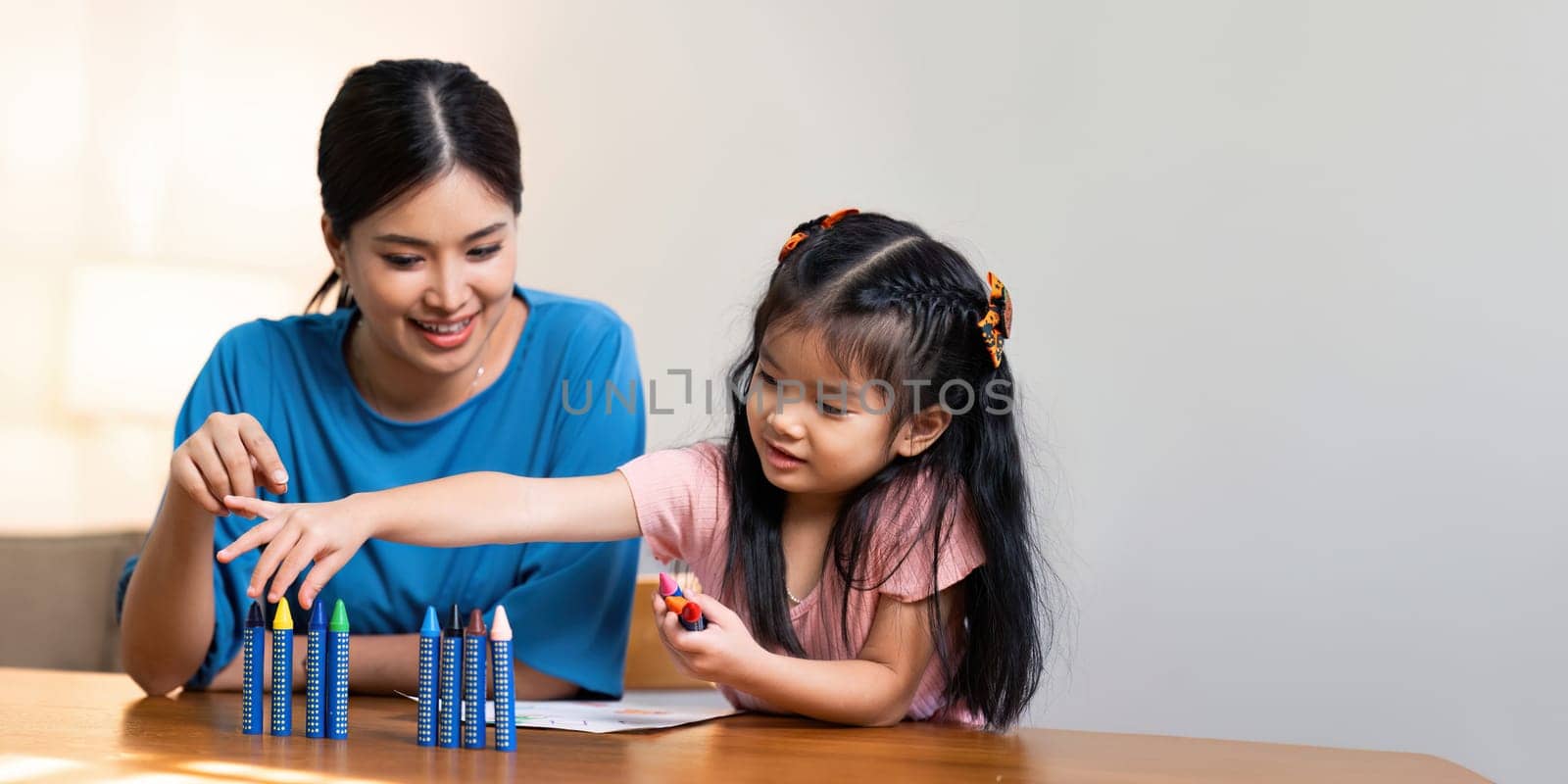 Happy family. Mother and daughter drawing together. Adult woman helping to child girl by itchaznong