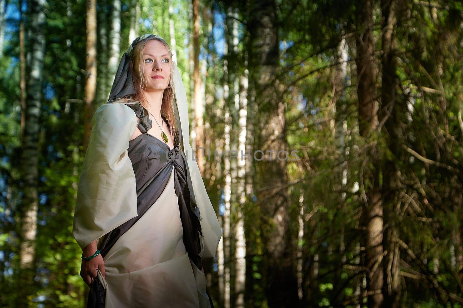 Beautiful seductive dryad. Pagan spirit of forest. Portrait of beautiful dryad. Fairy who loves nature in beautiful green summer forest. Concept of environmental friendliness and caring for nature