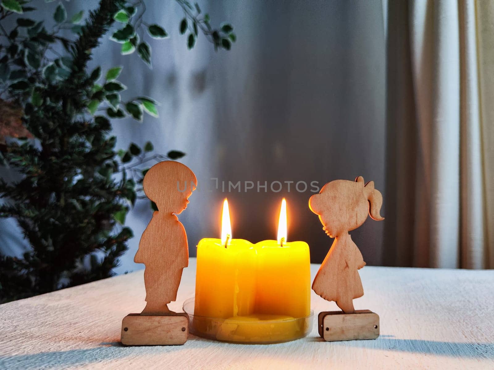 Wooden toys of boy and girl with yellow candles. Couple in love on Valentine's Day. Celebration of love, friendship. Card, background by keleny