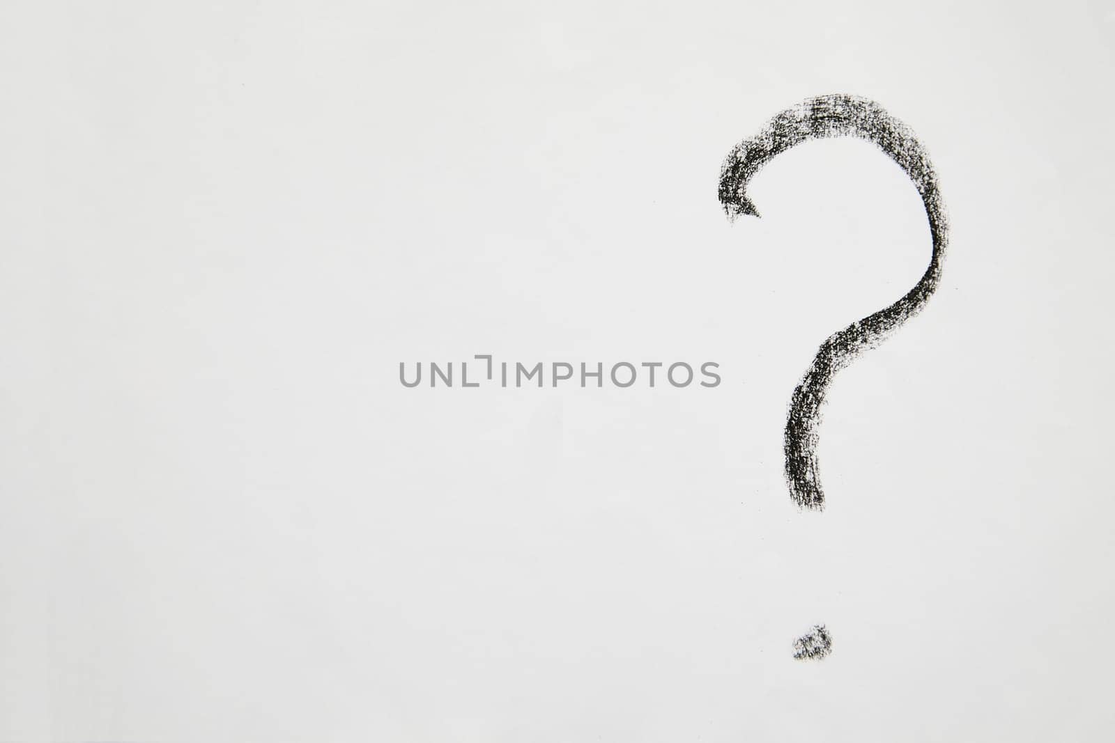 Handwritten question mark in black chalk on a white background. Business concept, doubts, insecurities