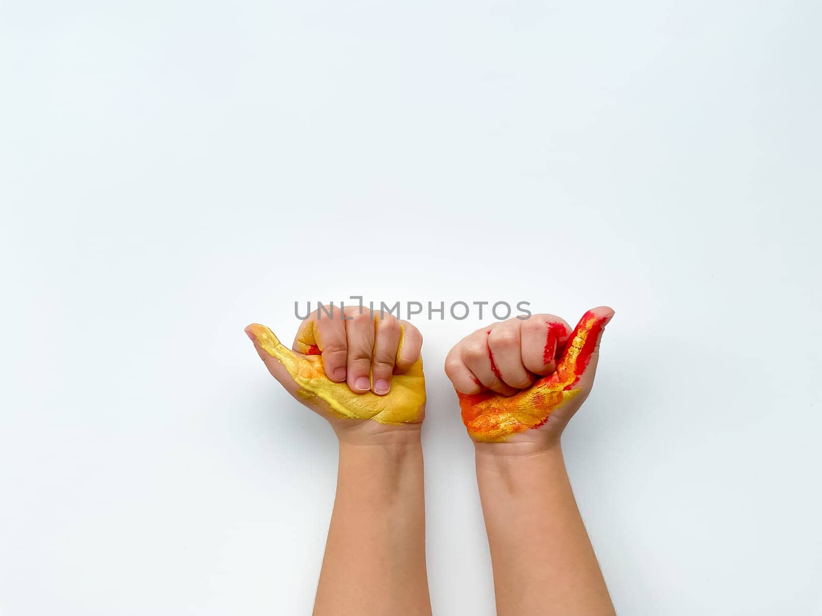 Childrens hands painted with yellow and red paint on white background. by Lunnica