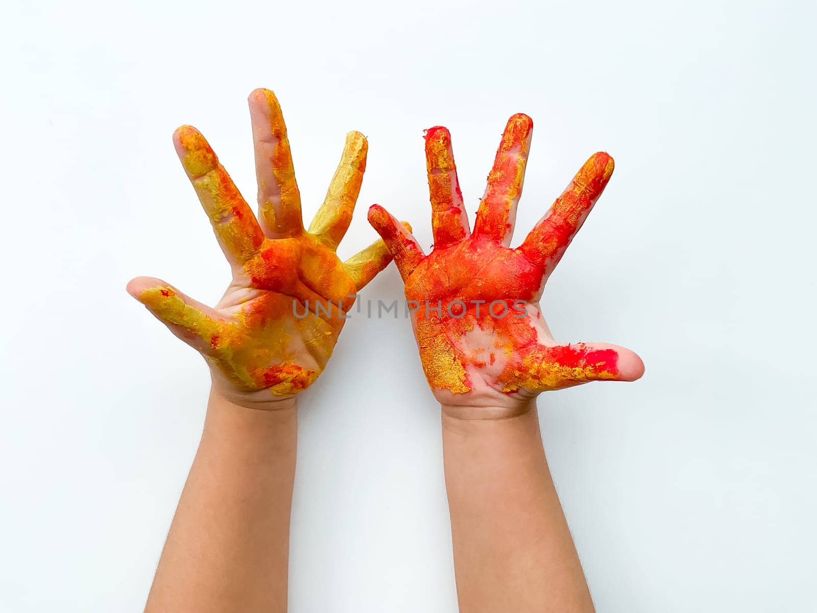 Childrens hands painted with yellow and red paint on white background. by Lunnica