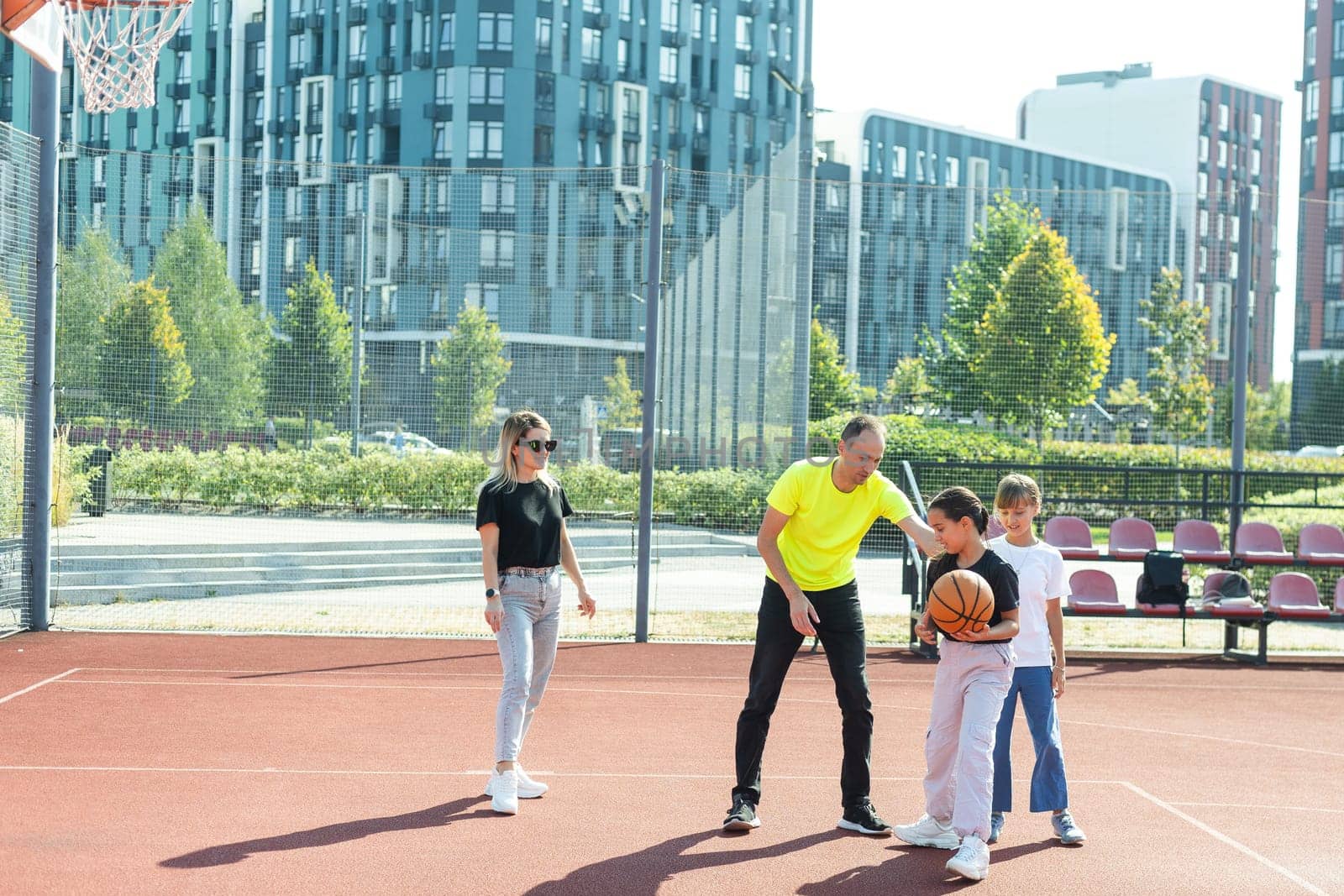 family playing basketball on court. High quality photo