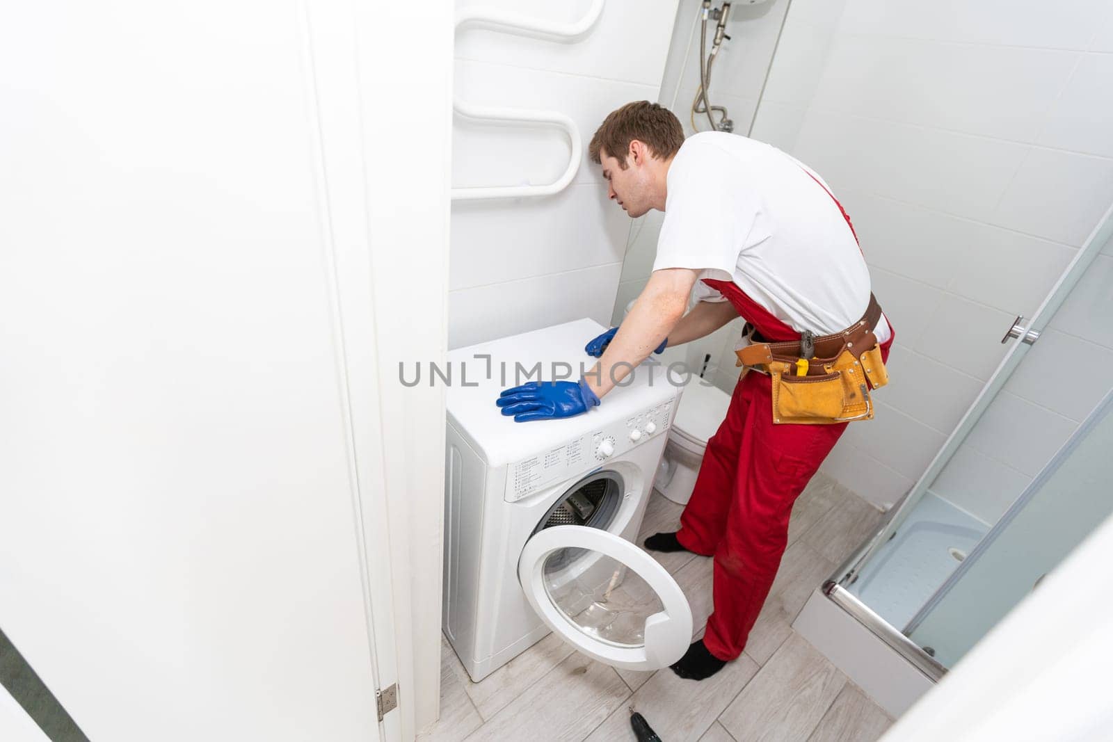 Plumber Fixing Domestic Washing Machine.