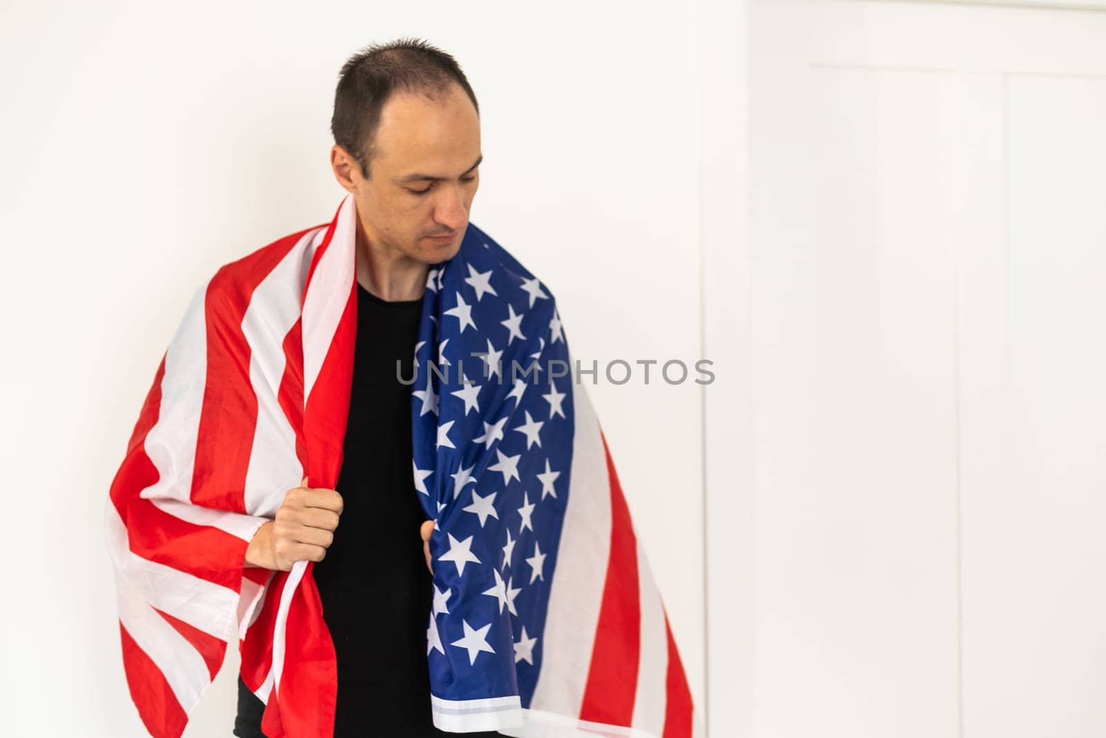 Man standing and putting country flag around the shoulder by Andelov13