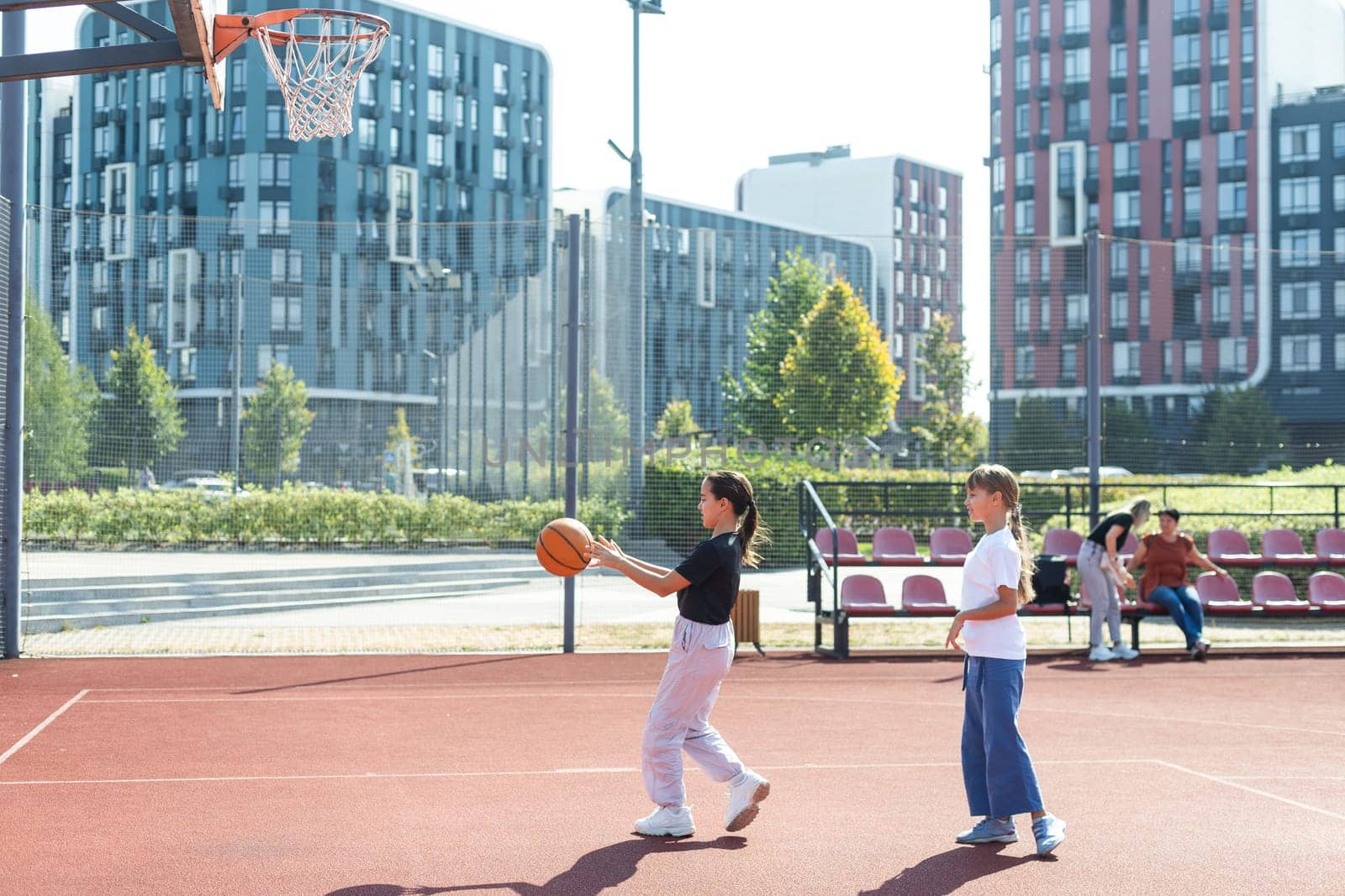 Children and sports. Teenage girl playing basketball on the playground. by Andelov13