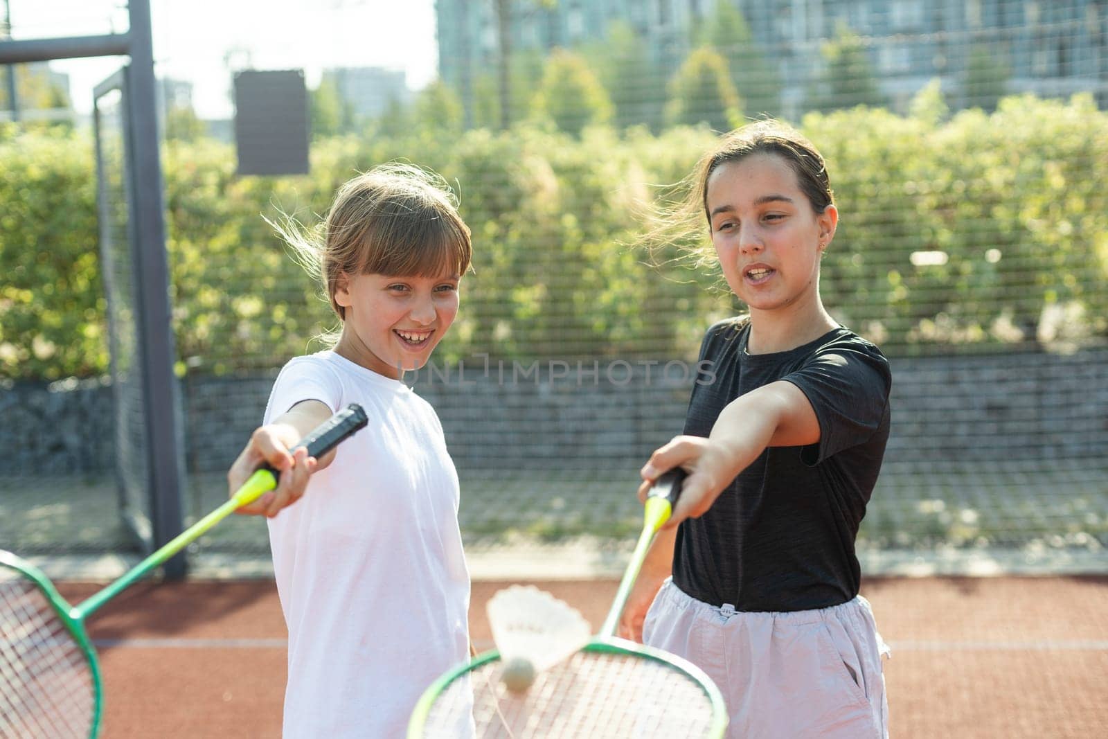 Young girls, athletes shaking hands before game session. Playing tennis on warm sunny day at open air tennis court. Concept of sport, hobby, active lifestyle, health, endurance and strength, ad by Andelov13